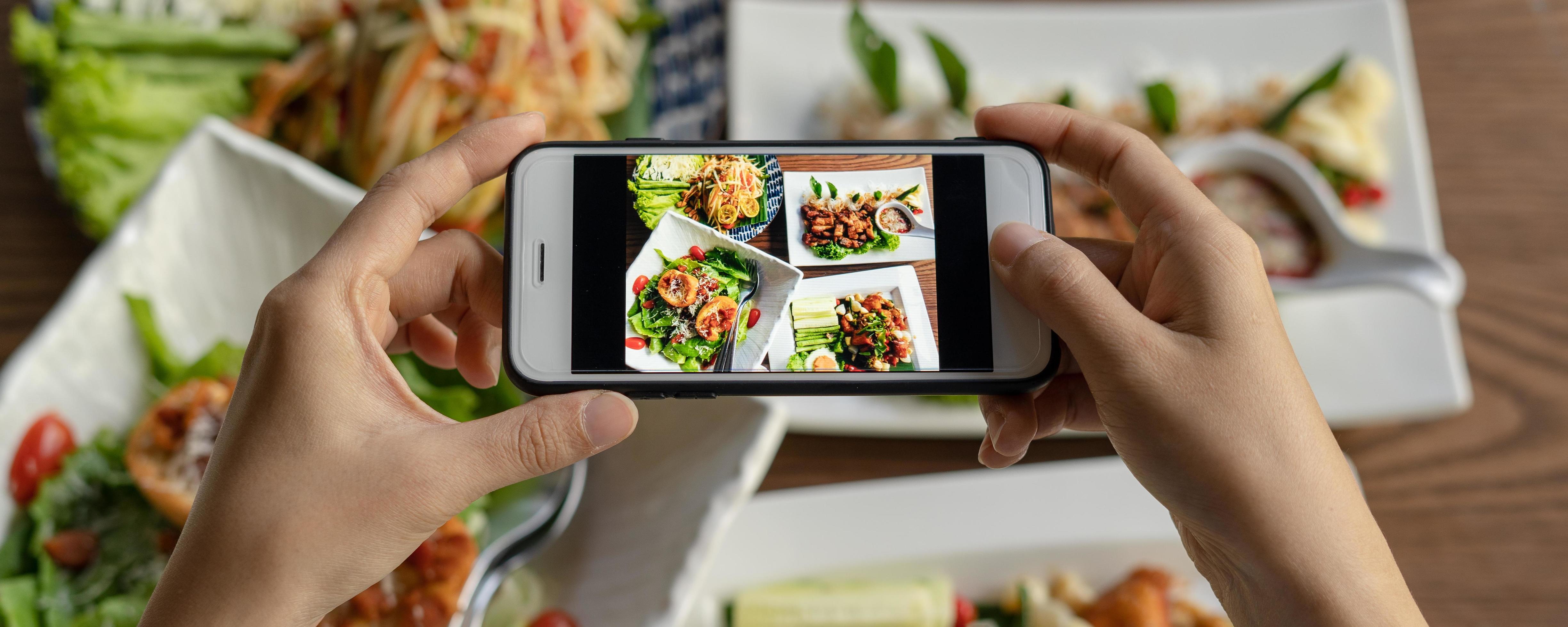 Woman take picture of a meal on the table after ordering food online to eat at home. Photography and use phone concepts Stock Free