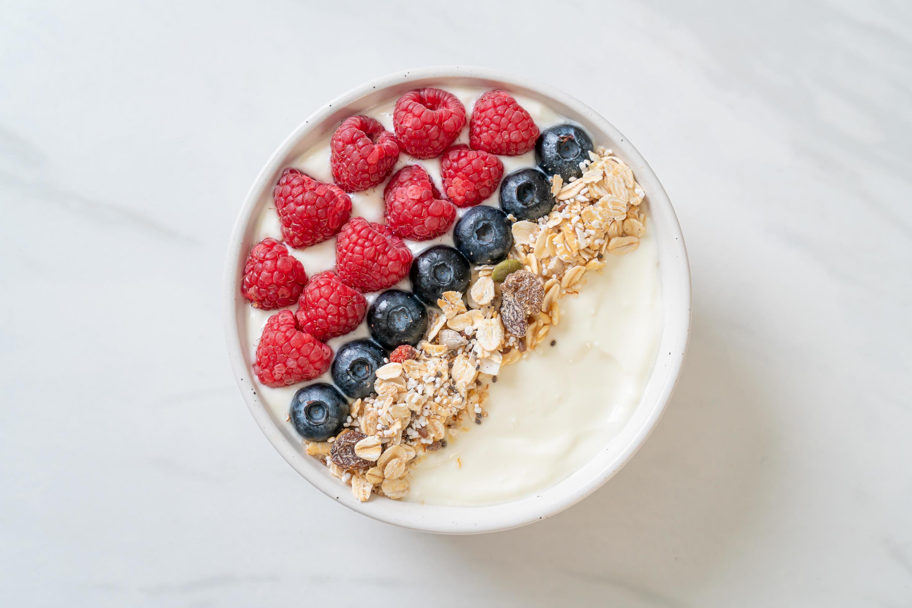 Homemade yogurt bowl with raspberry, blueberry and granola – healthy food style Stock Free