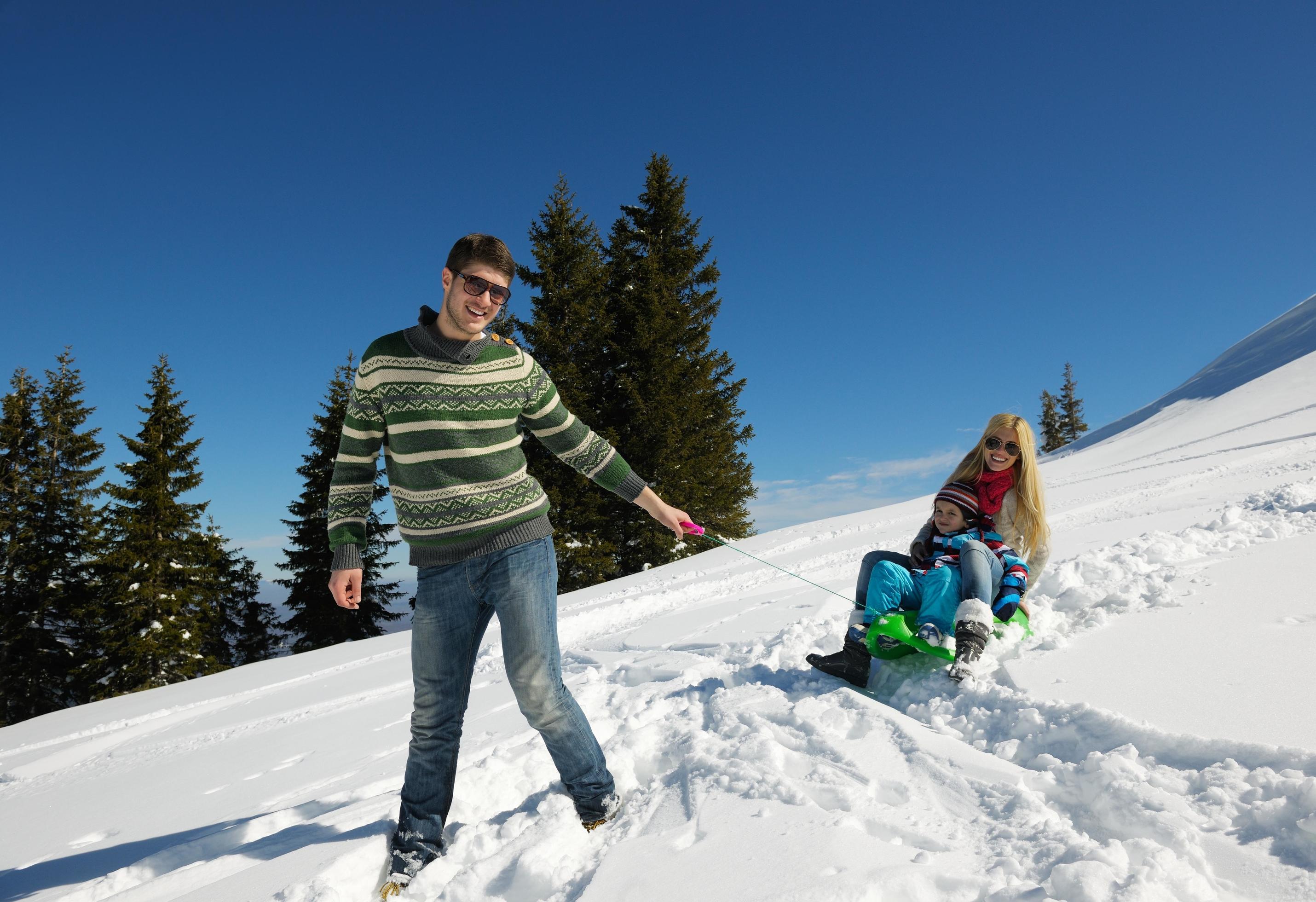 family having fun on fresh snow at winter vacation Stock Free