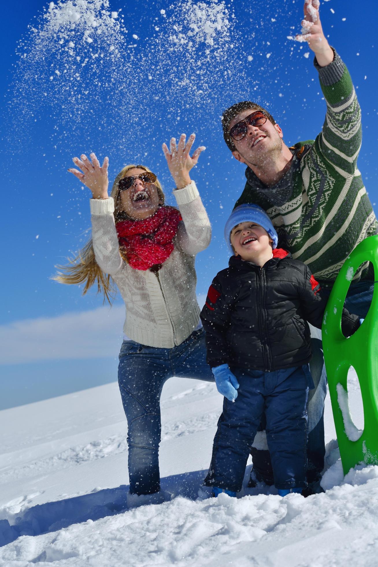 family having fun on fresh snow at winter vacation Stock Free