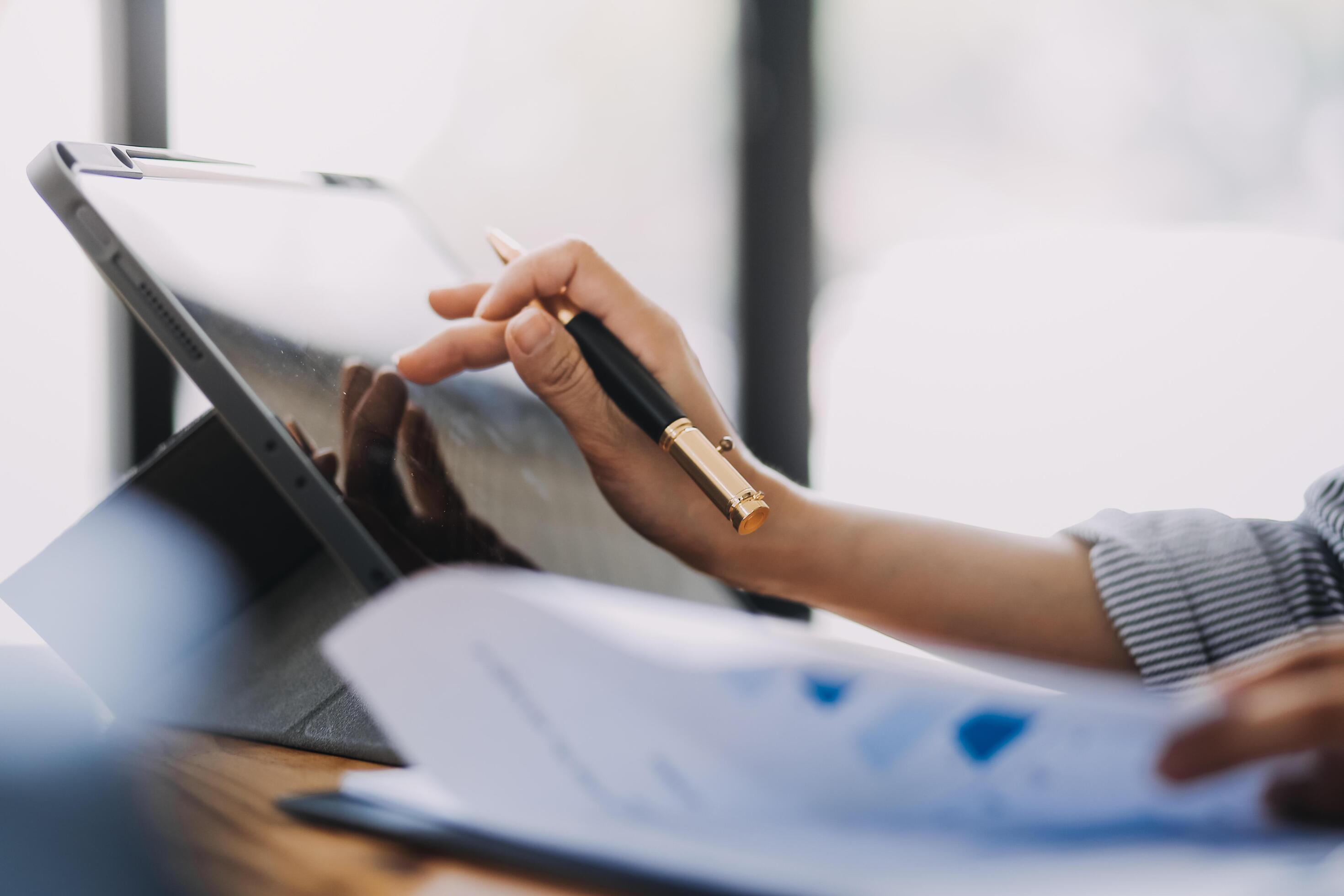 Portrait of Asian young female working on laptop and financial report at office. Stock Free