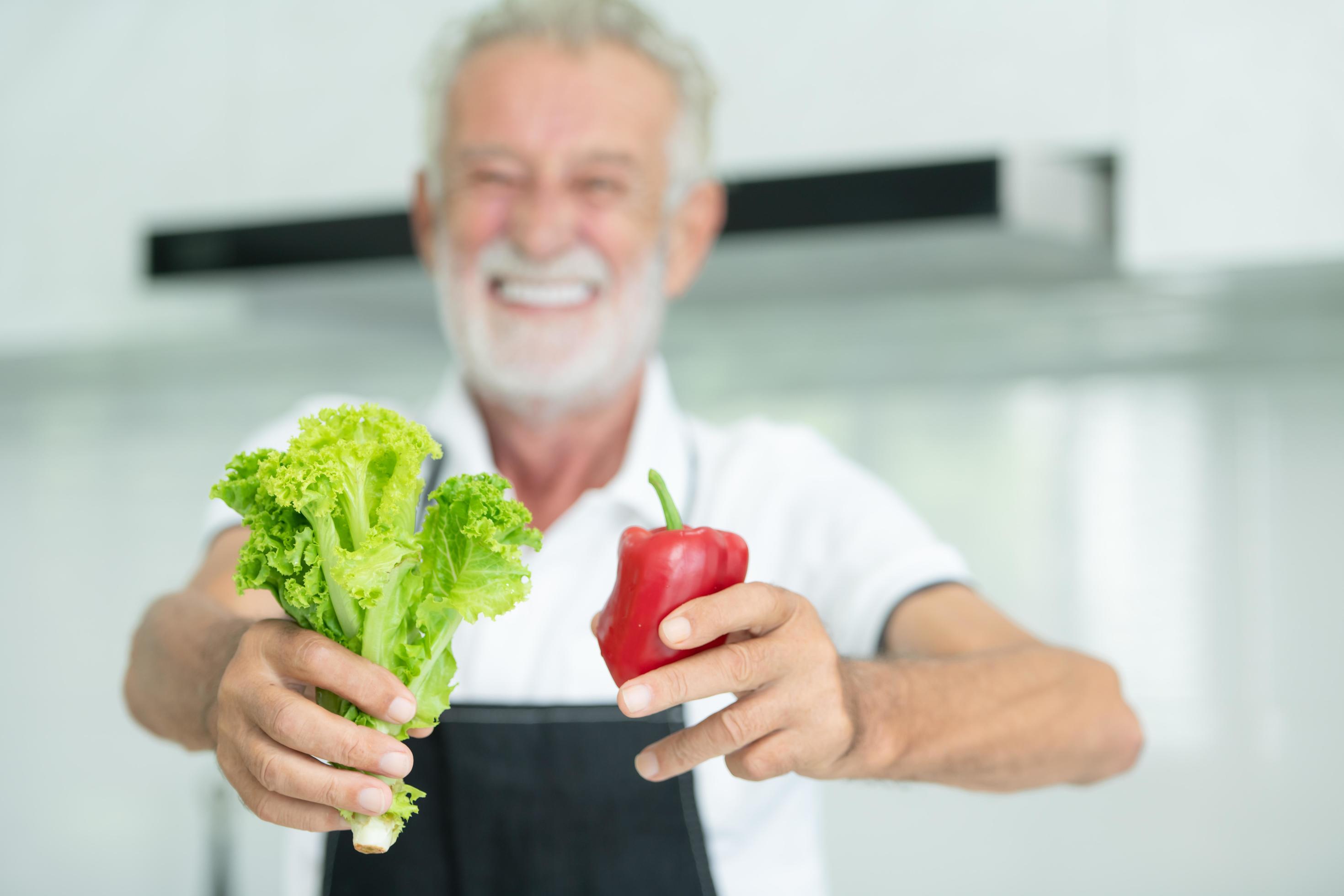 Grandfather is cooking breakfast and prepare food for grandchildren in the kitchen of the house. Stock Free