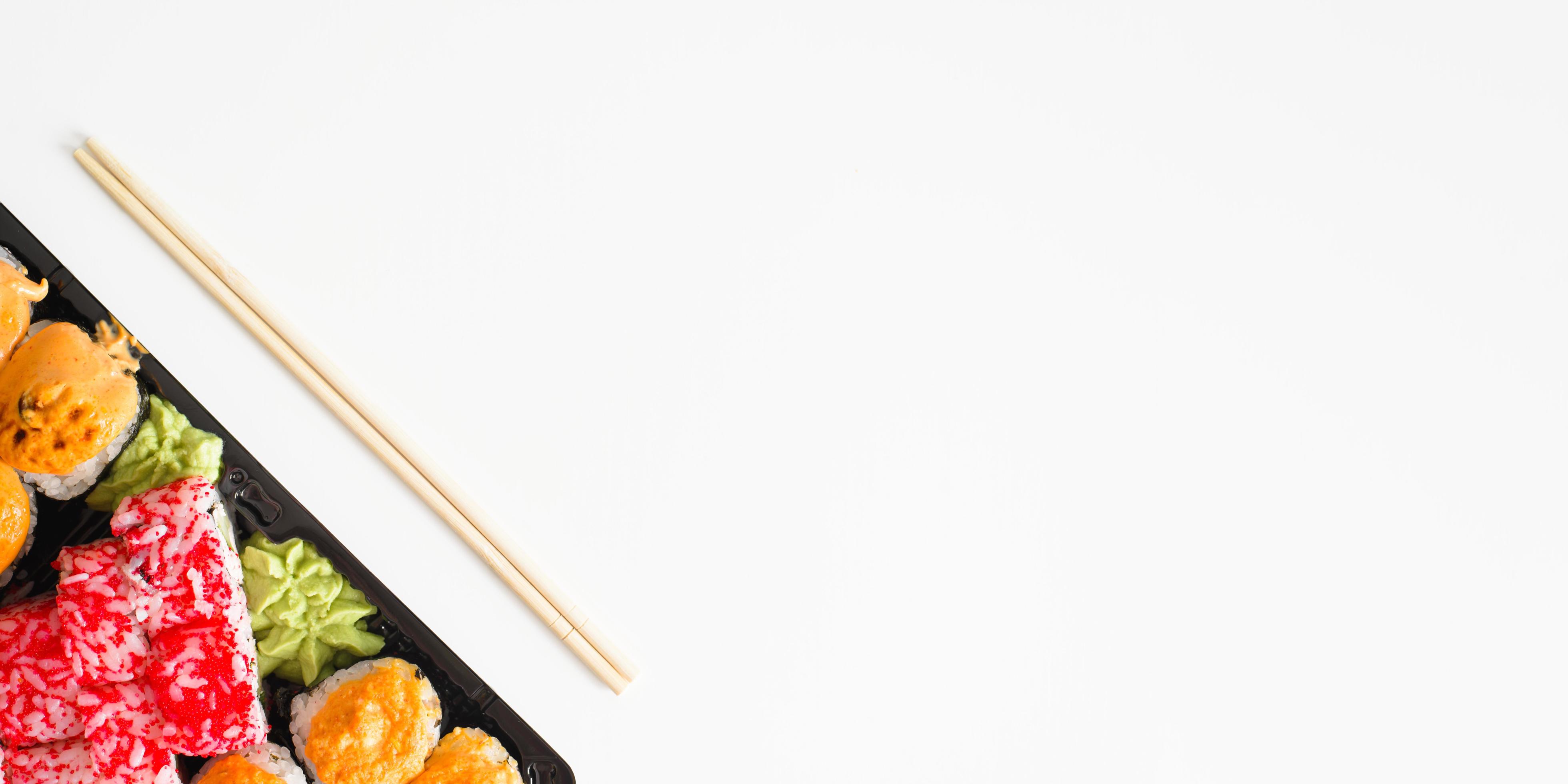 Japanese traditional food banner, copy space. Set of sushi and rolls and chopsticks, top view. Stock Free