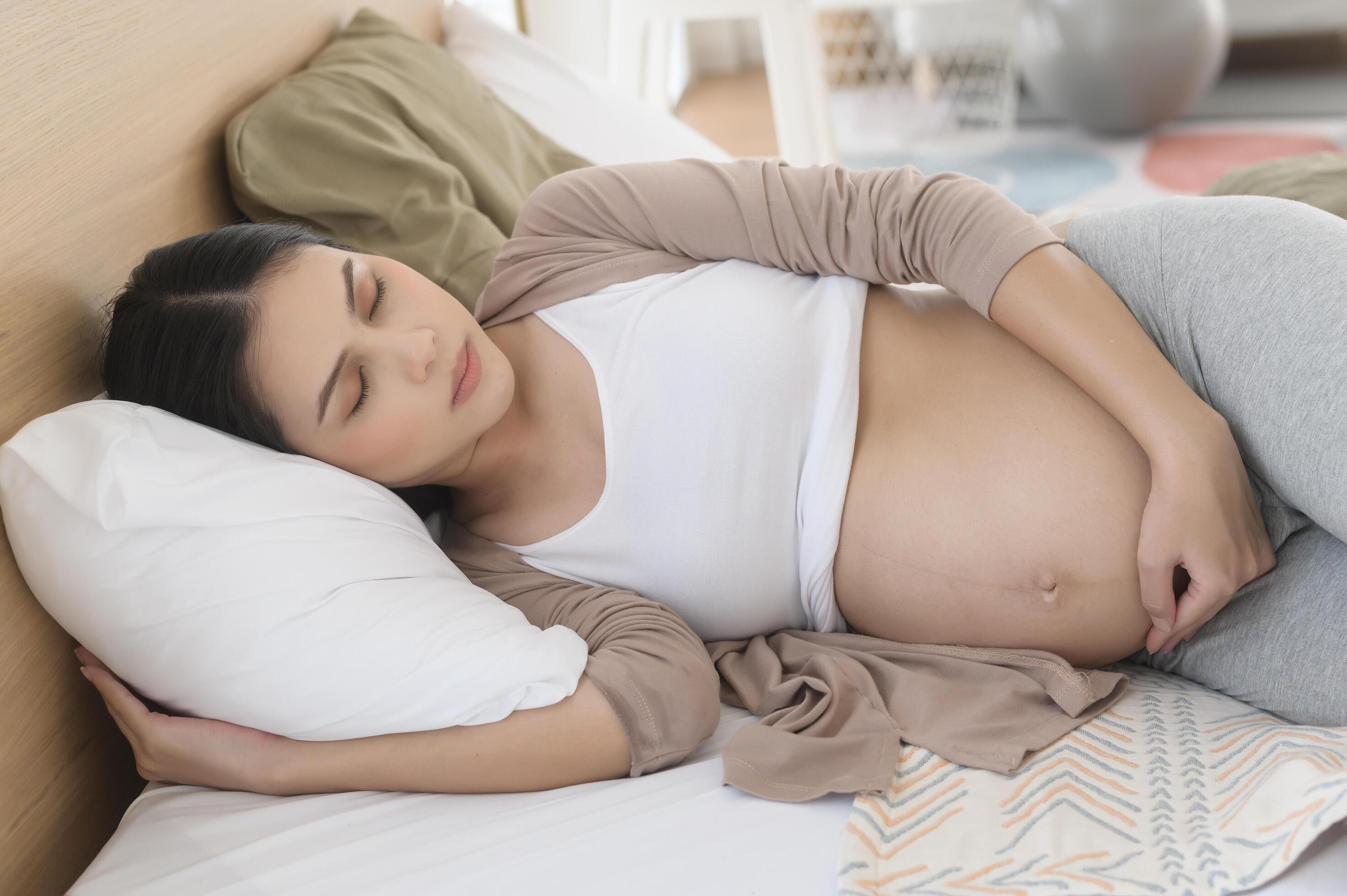 Pregnant woman sleeping on the bed, pregnancy and expectation concept Stock Free