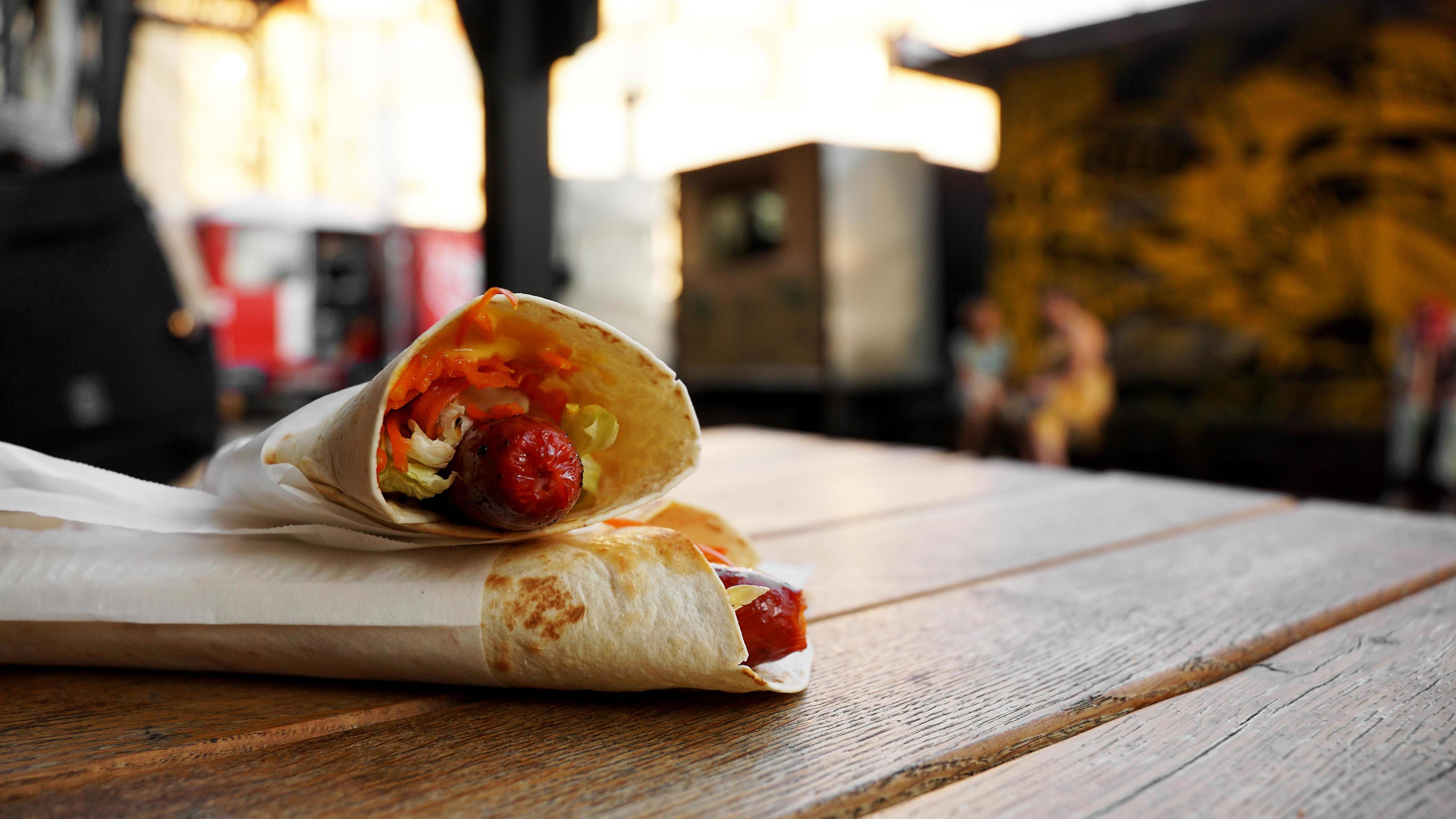 Hot dog in pita bread on a wooden table. Street food at food court Stock Free