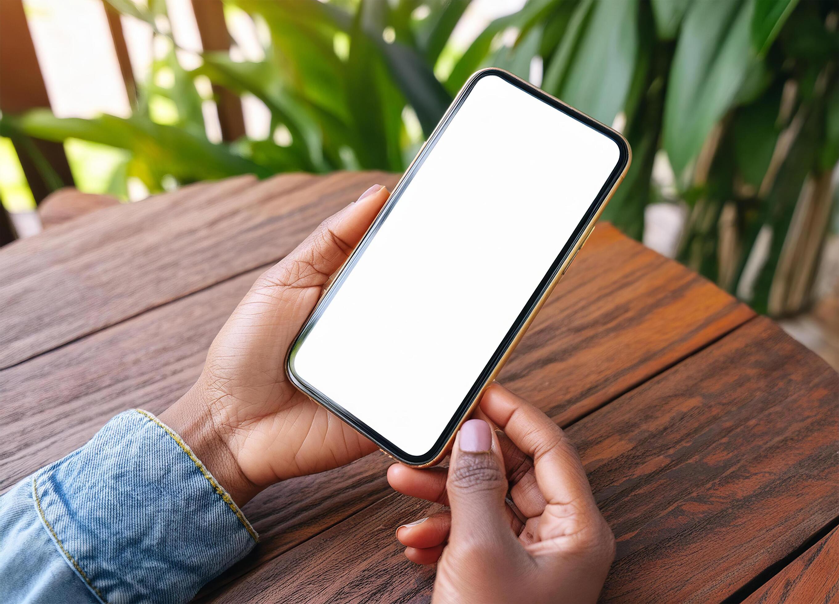 Woman Holds Smart Phone With Blank Screen on the wood table Stock Free