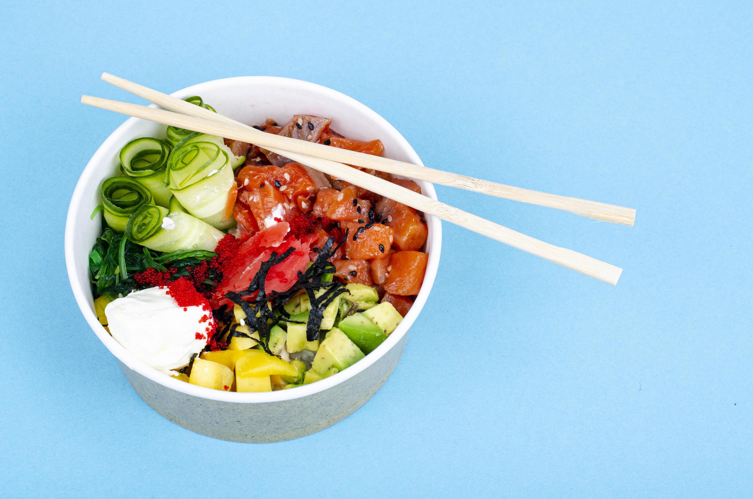 Poke with sea food and vegetables on blue background. Studio Photo Stock Free