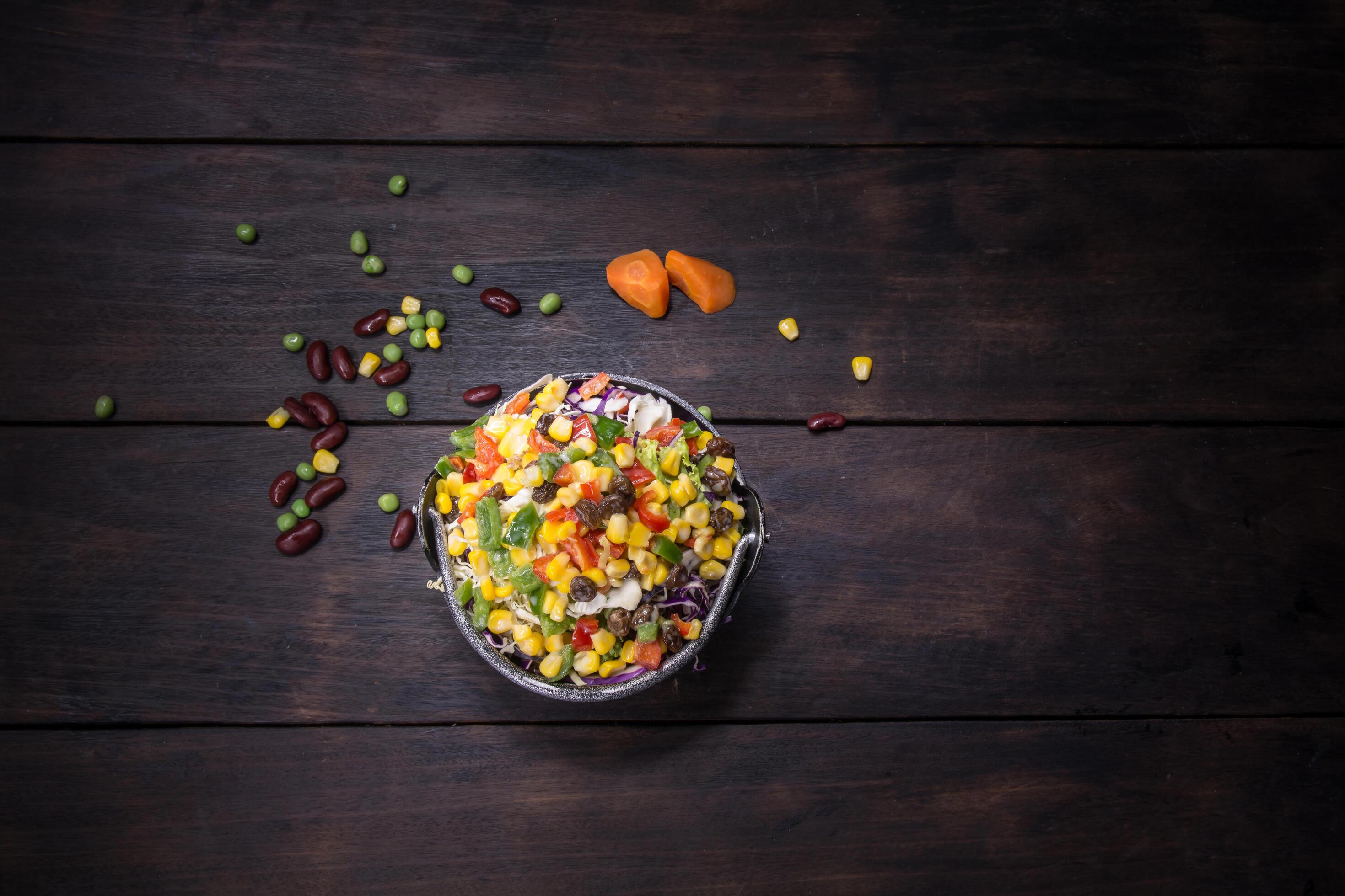 Fresh salad with corn and mixed on wooden background top view. Healthy food. Stock Free