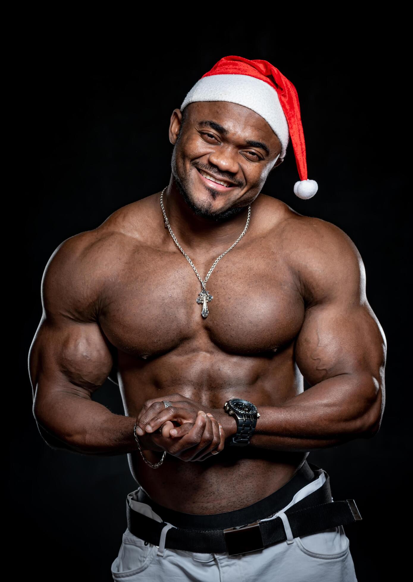 Holiday of christmas wih sporty male model. Athletic muscular man without shirt with a santa hat. Stock Free