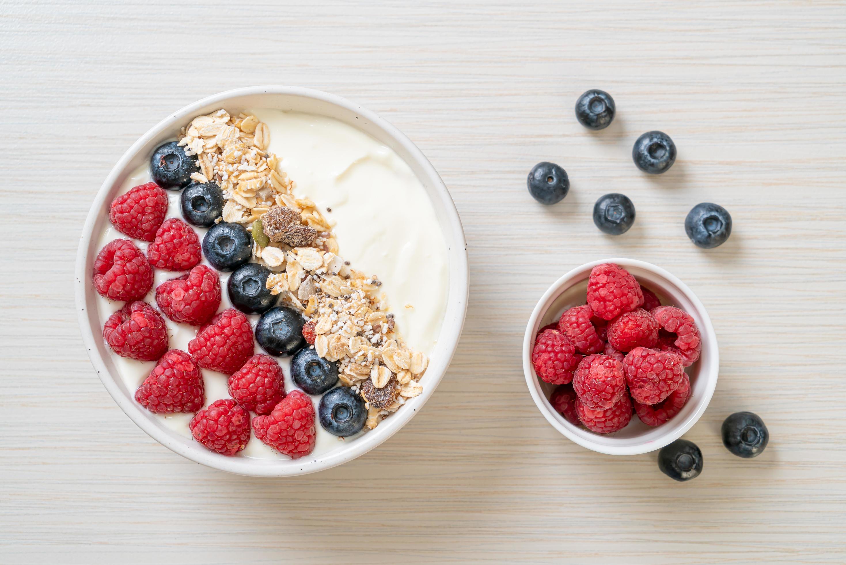 Homemade yogurt bowl with raspberry, blueberry and granola – healthy food style Stock Free