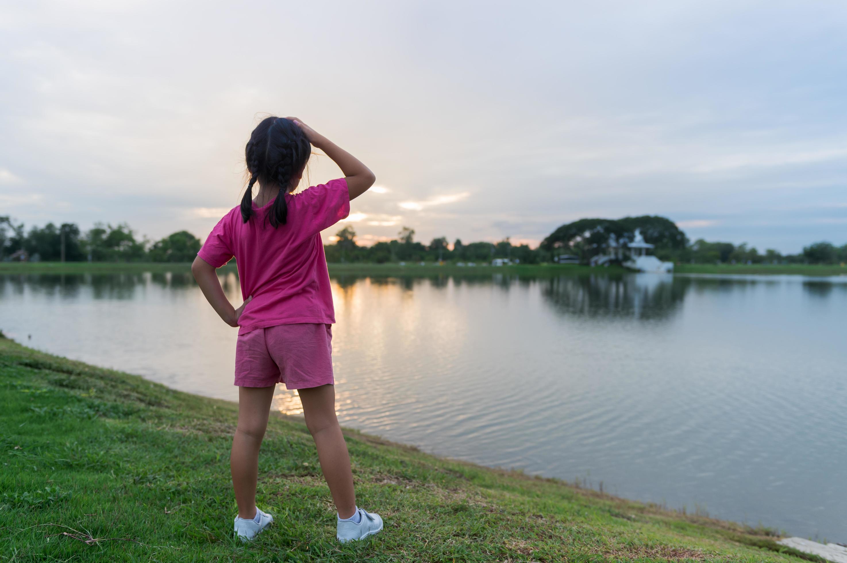 back side of little girl exercise on park with sunset Stock Free