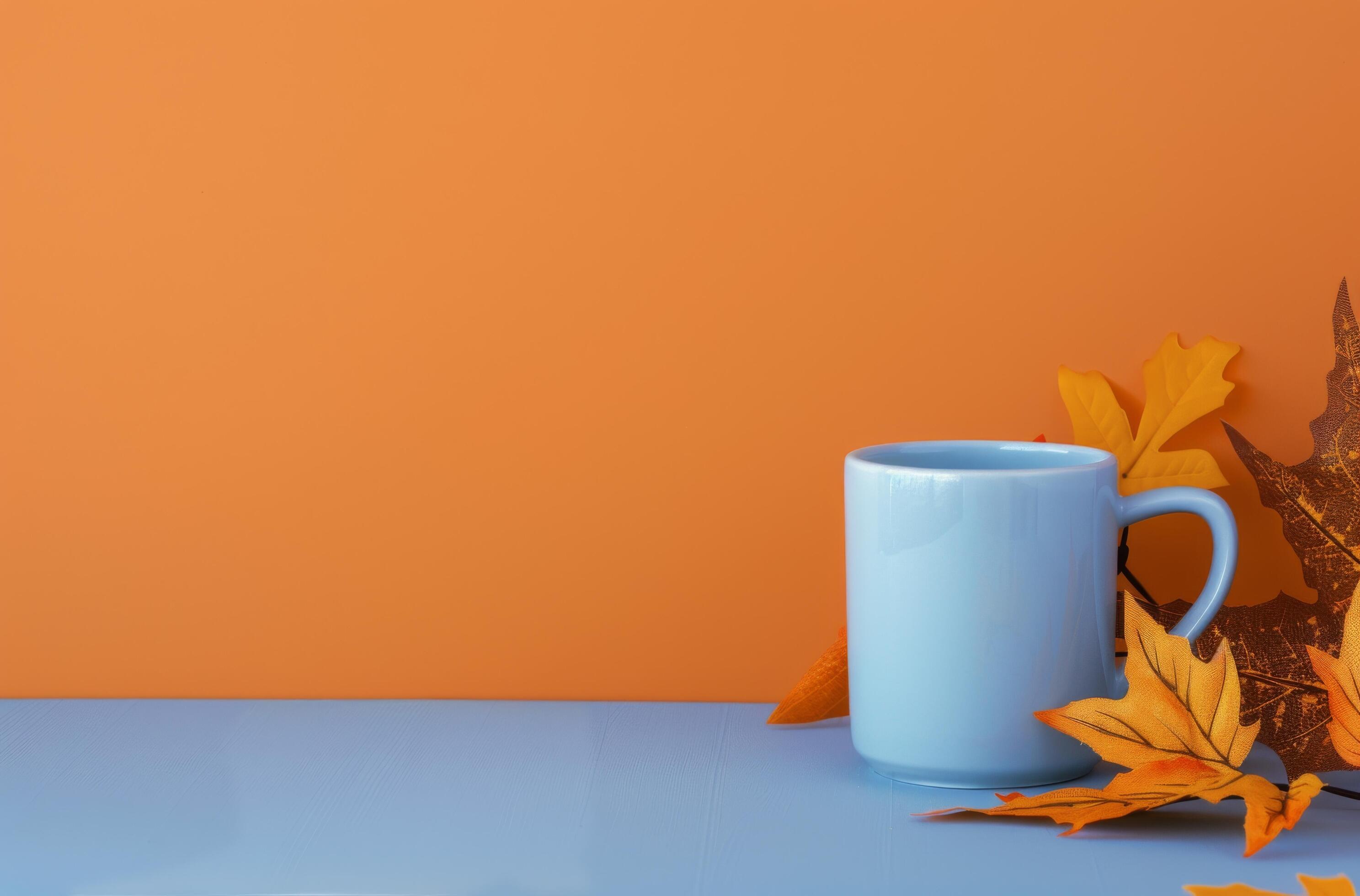 White Mug With Fall Leaves on Orange Background Stock Free