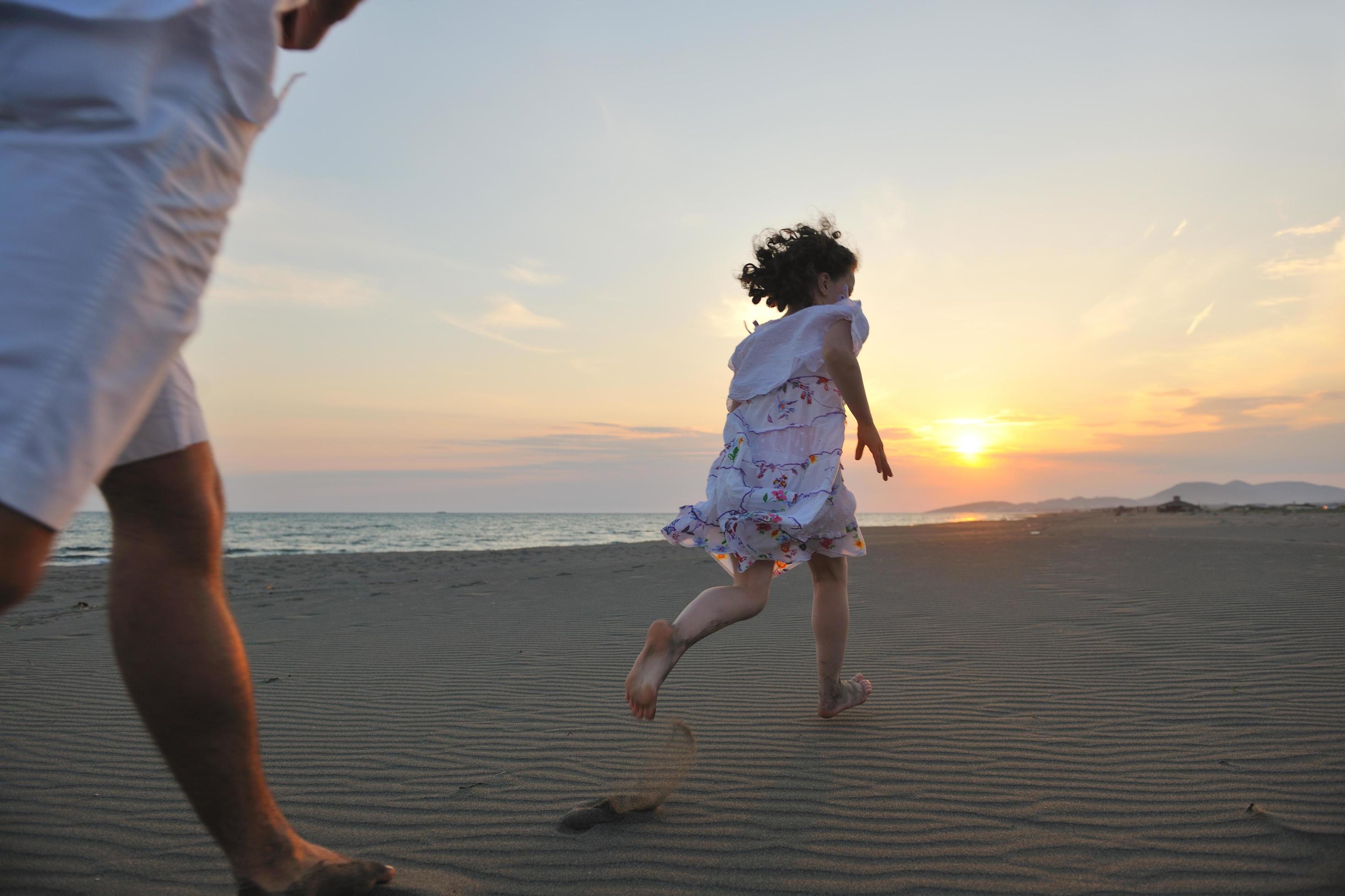 happy young family have fun on beach at sunset Stock Free