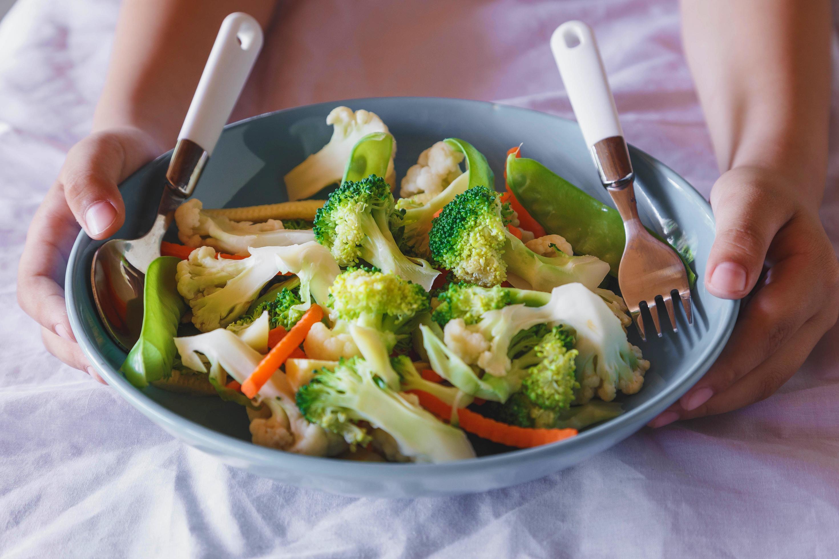 Mixed vegetable food on the bowl in the hand, healthy mixed vegetables. Stock Free