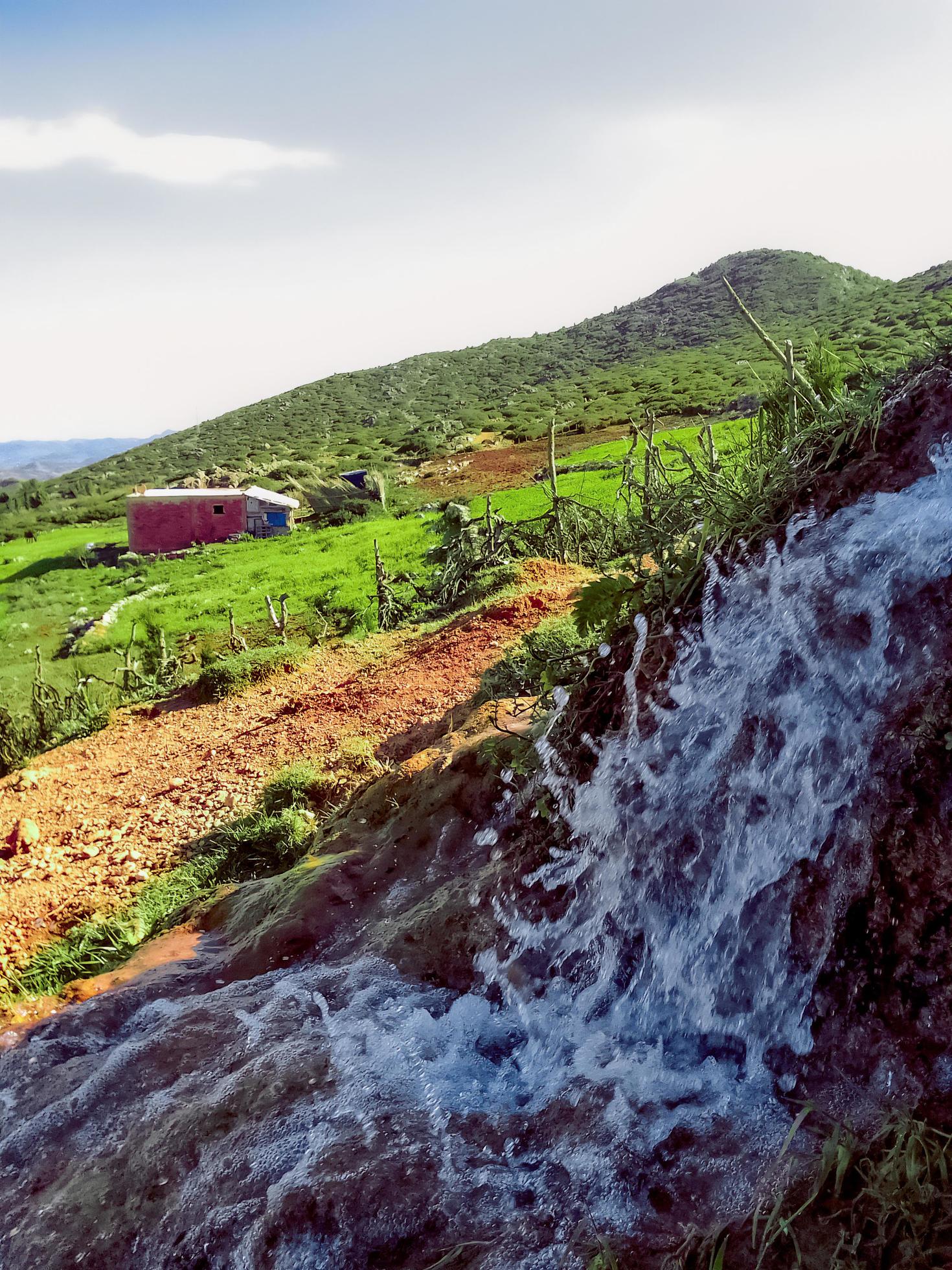 Tranquil charm of a water spring near a country house a journey into the heart of rural peace and natural grandeur Stock Free