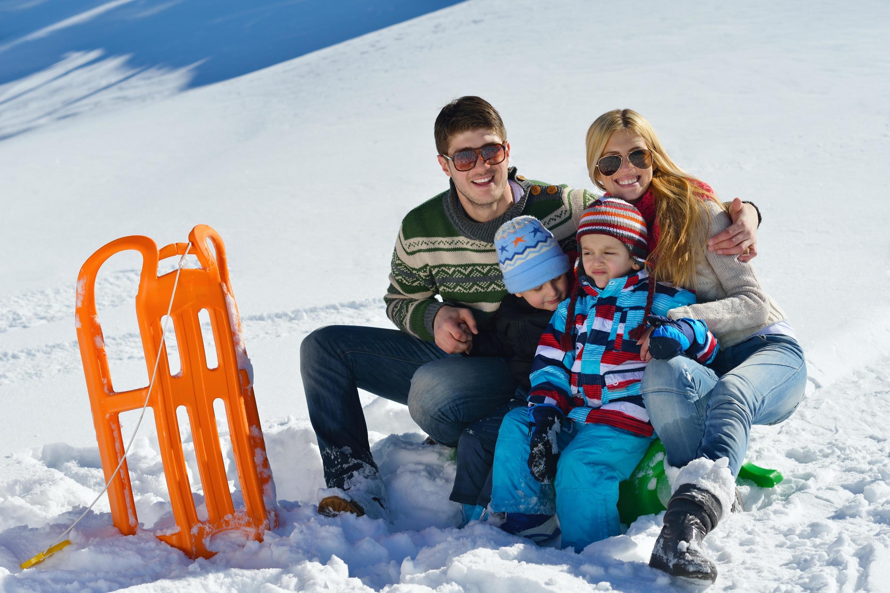 family having fun on fresh snow at winter vacation Stock Free