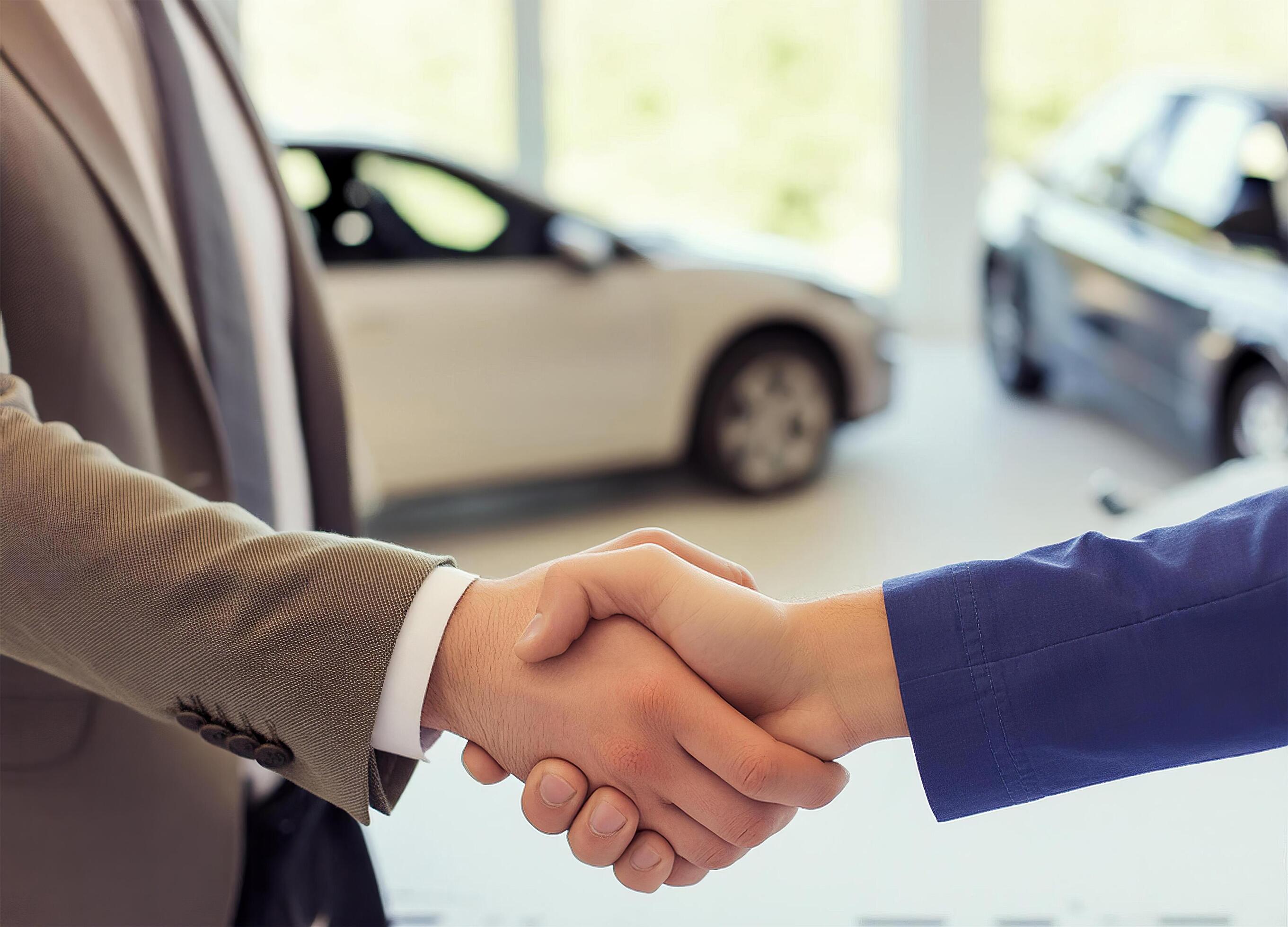 Close up of handshake in the car dealership offices Stock Free