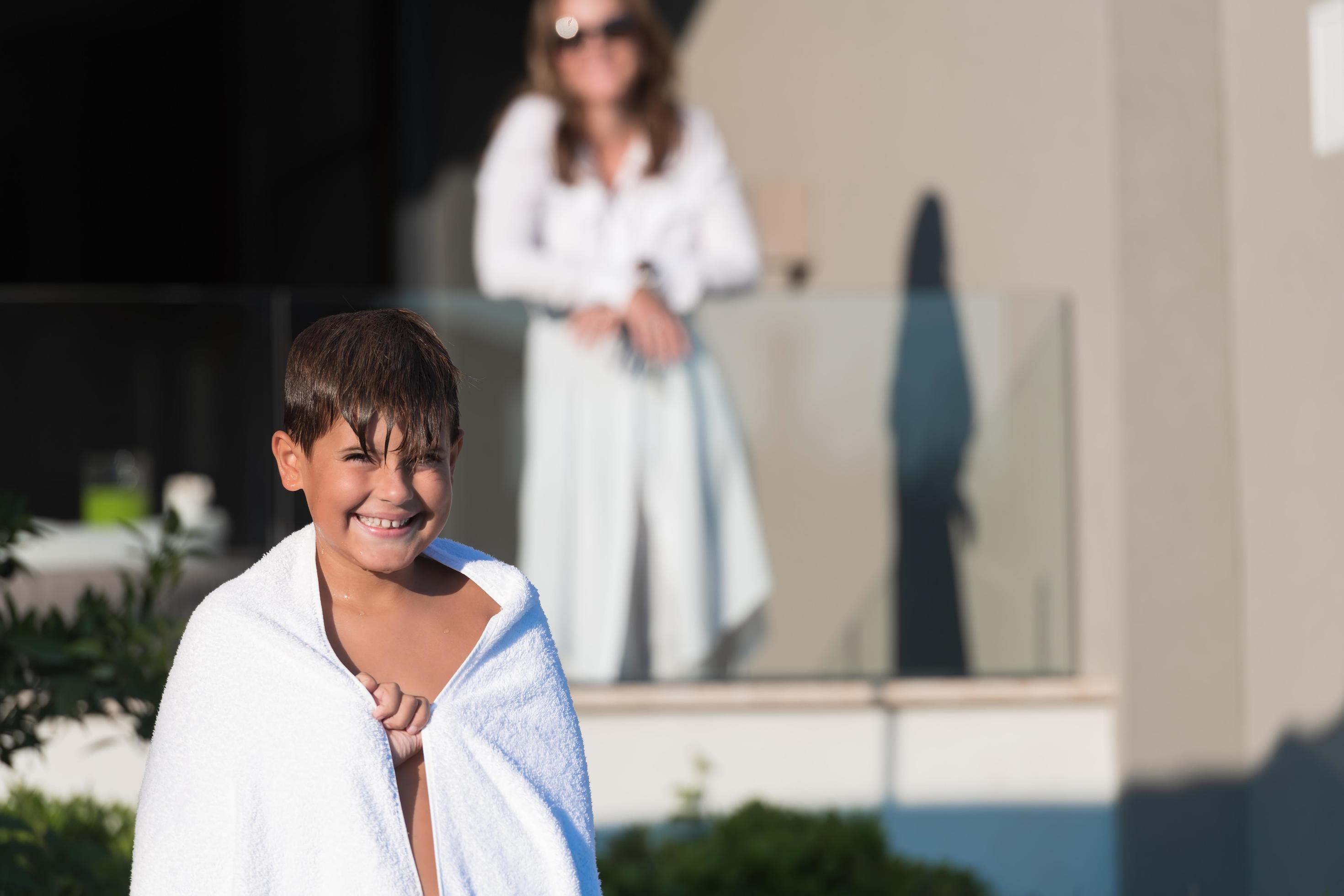 The boy enjoys a summer day swimming in the pool. The concept of a family vacation. Selective focus Stock Free