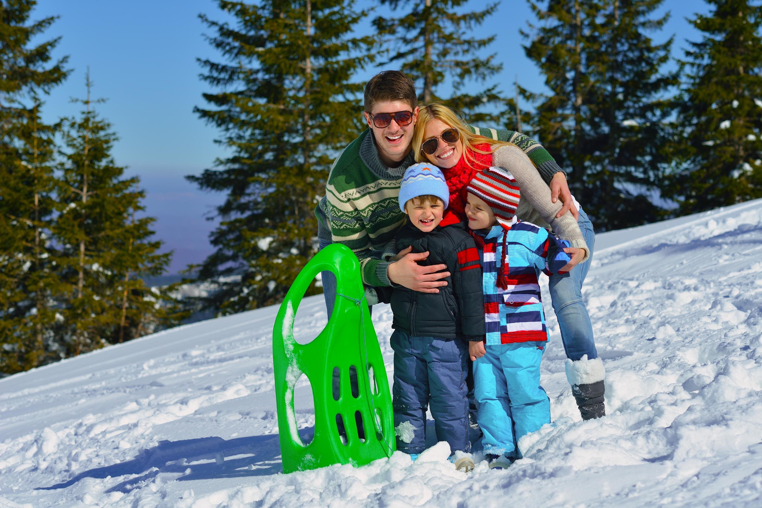 family having fun on fresh snow at winter vacation Stock Free