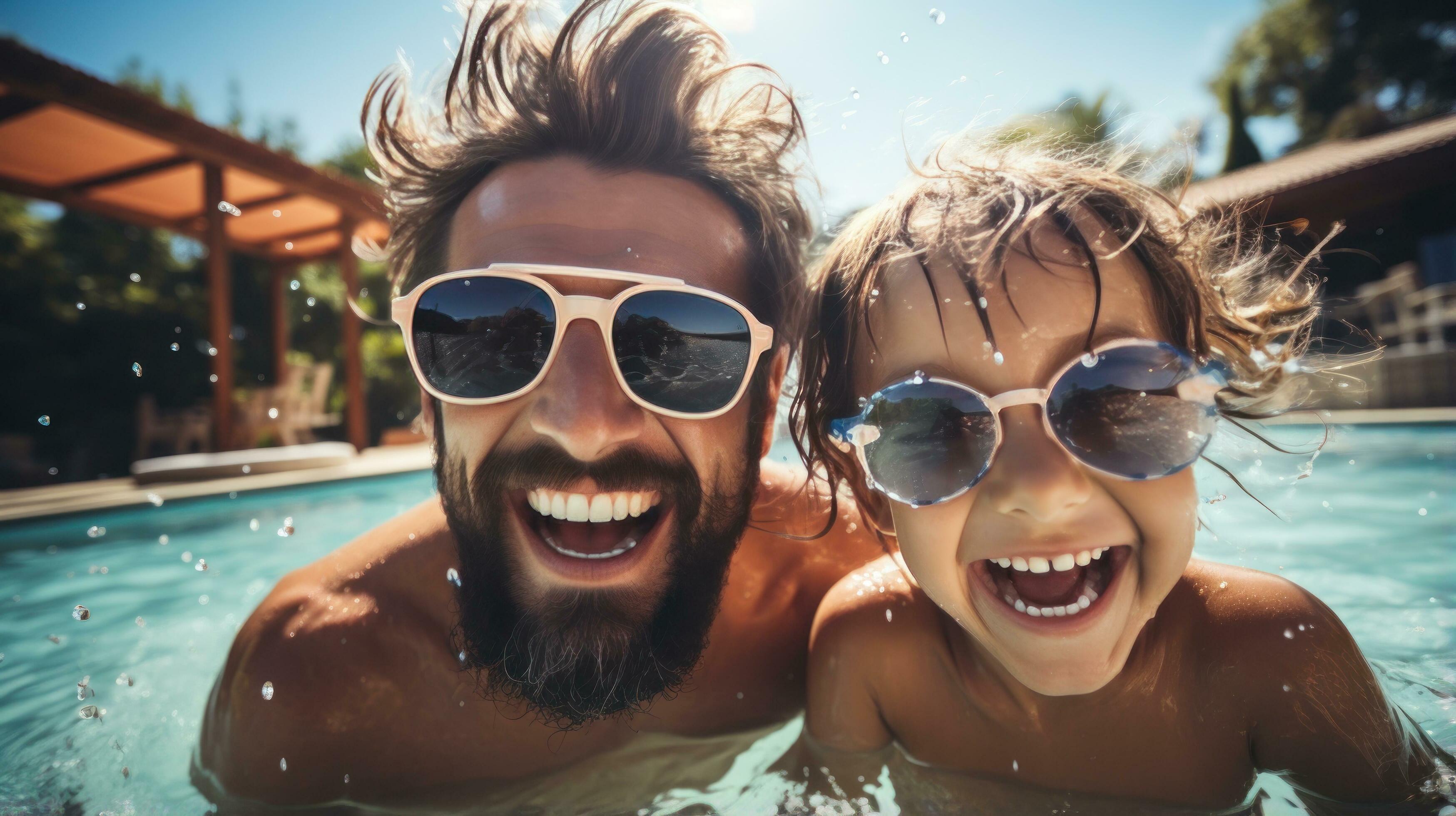 Happy family having fun in the pool on a sunny day Stock Free