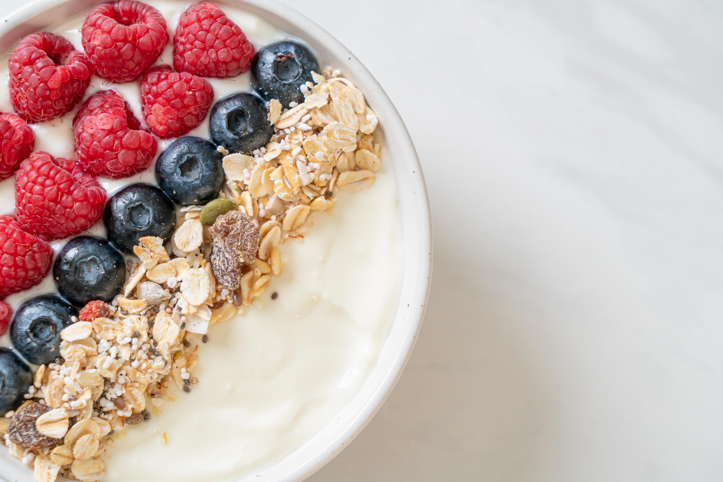 Homemade yogurt bowl with raspberry, blueberry and granola – healthy food style Stock Free