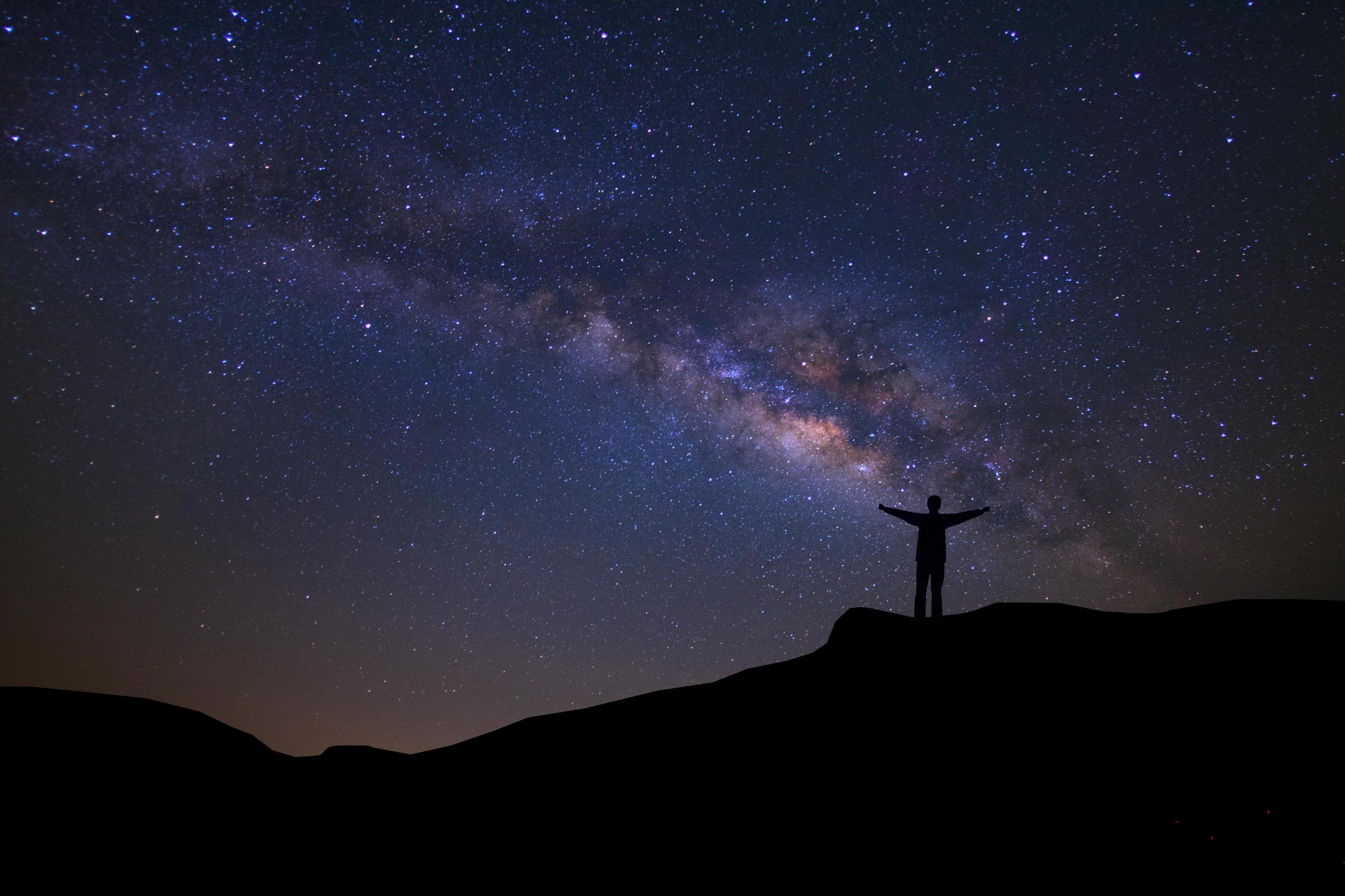 Landscape with milky way, Night sky with stars and silhouette of happy people standing on the mountain, Long exposure photograph, with grain Stock Free