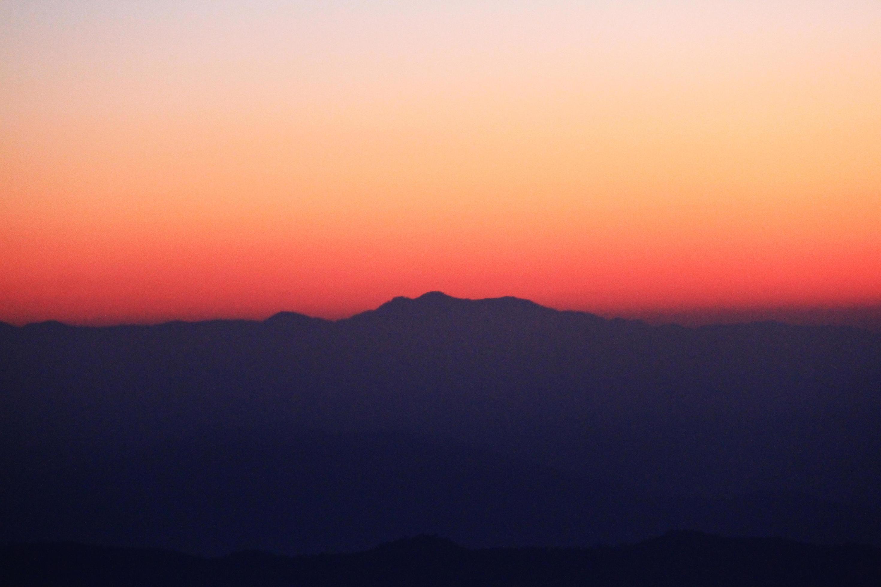 Sunset in sky and cloud, beautiful colorful twilight time with silhouette of mountain. Stock Free