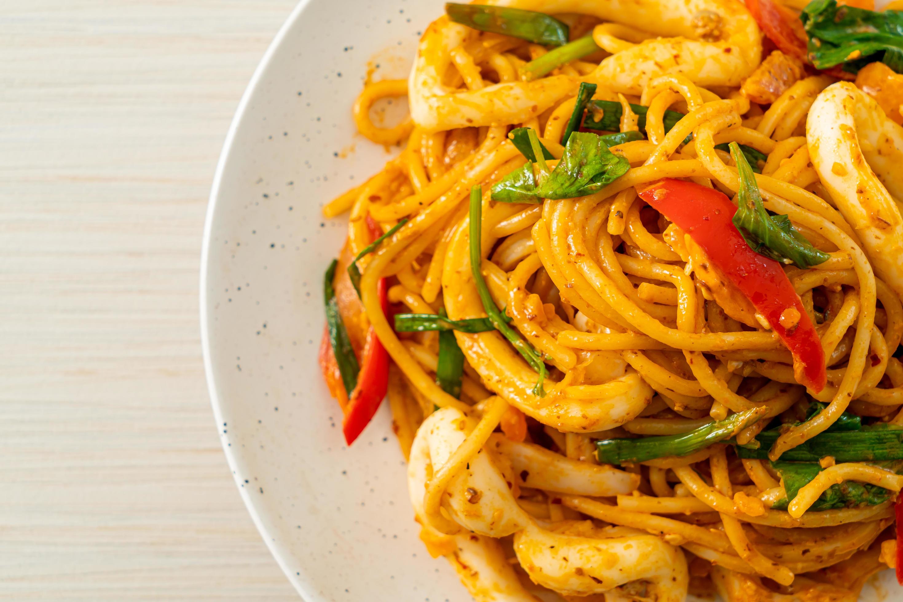 Stir-fried spaghetti with salted egg and squid – fusion food style Stock Free