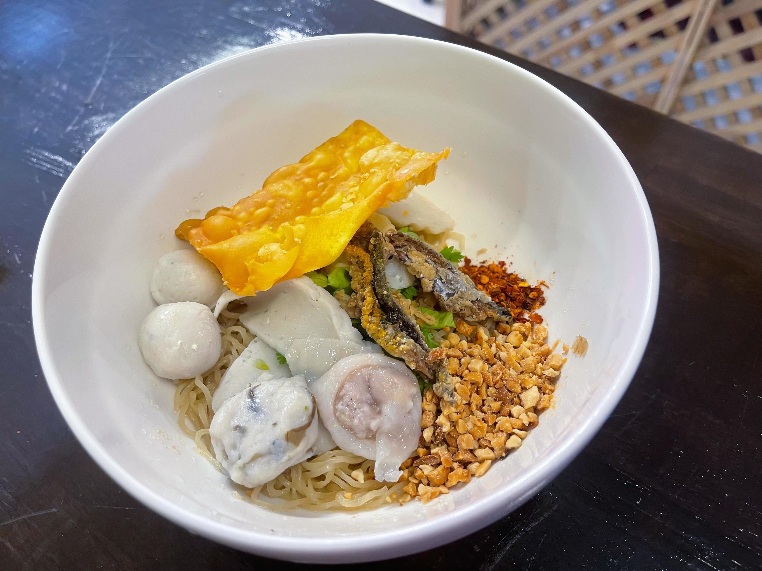 Thailand traditional dry noodles served with fish ball, fried tofu and other. A popular delicious street food of Thai peoples. Asian food. Stock Free