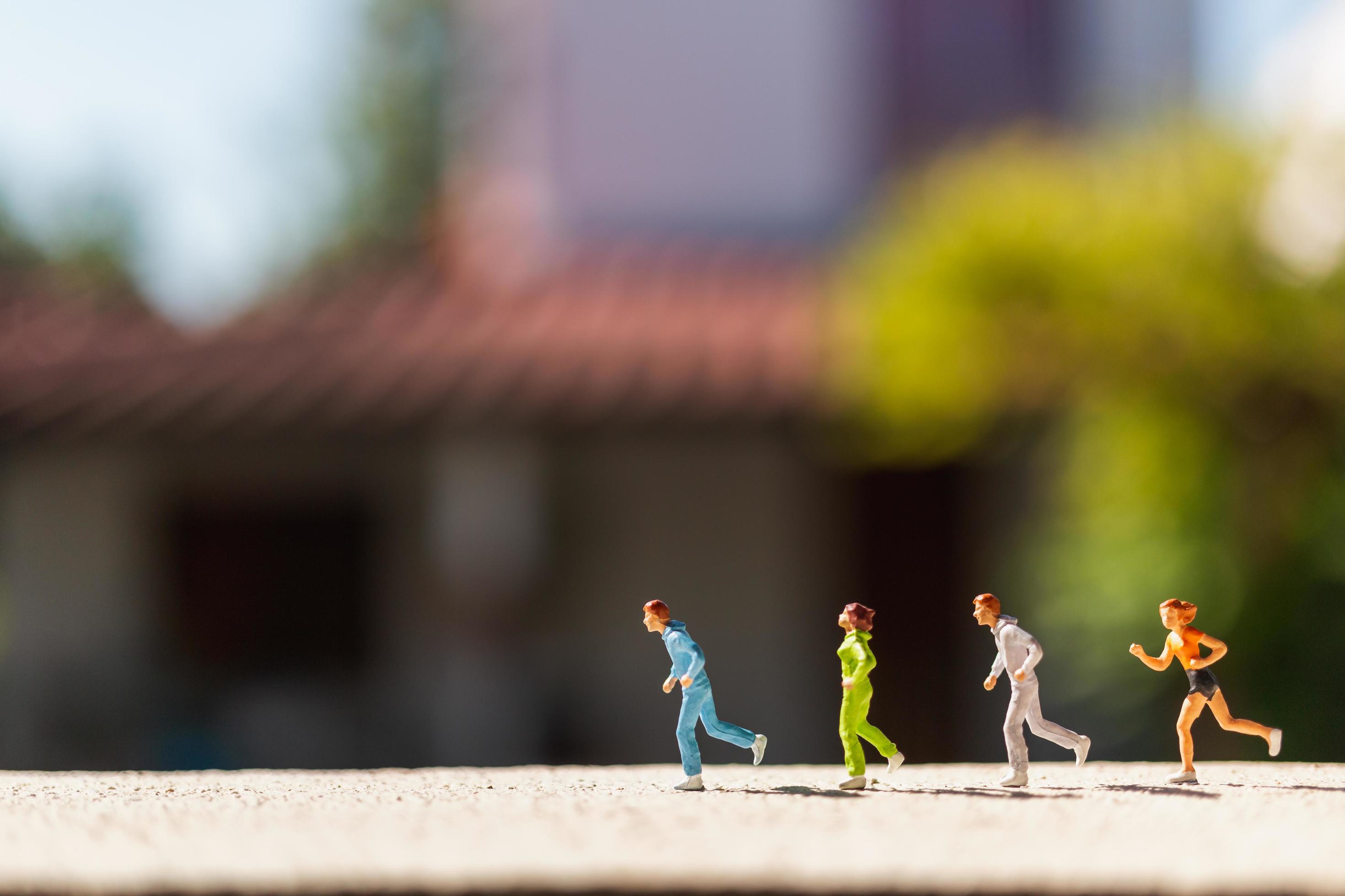 Miniature group of people running on a concrete road, healthy lifestyle concept Stock Free