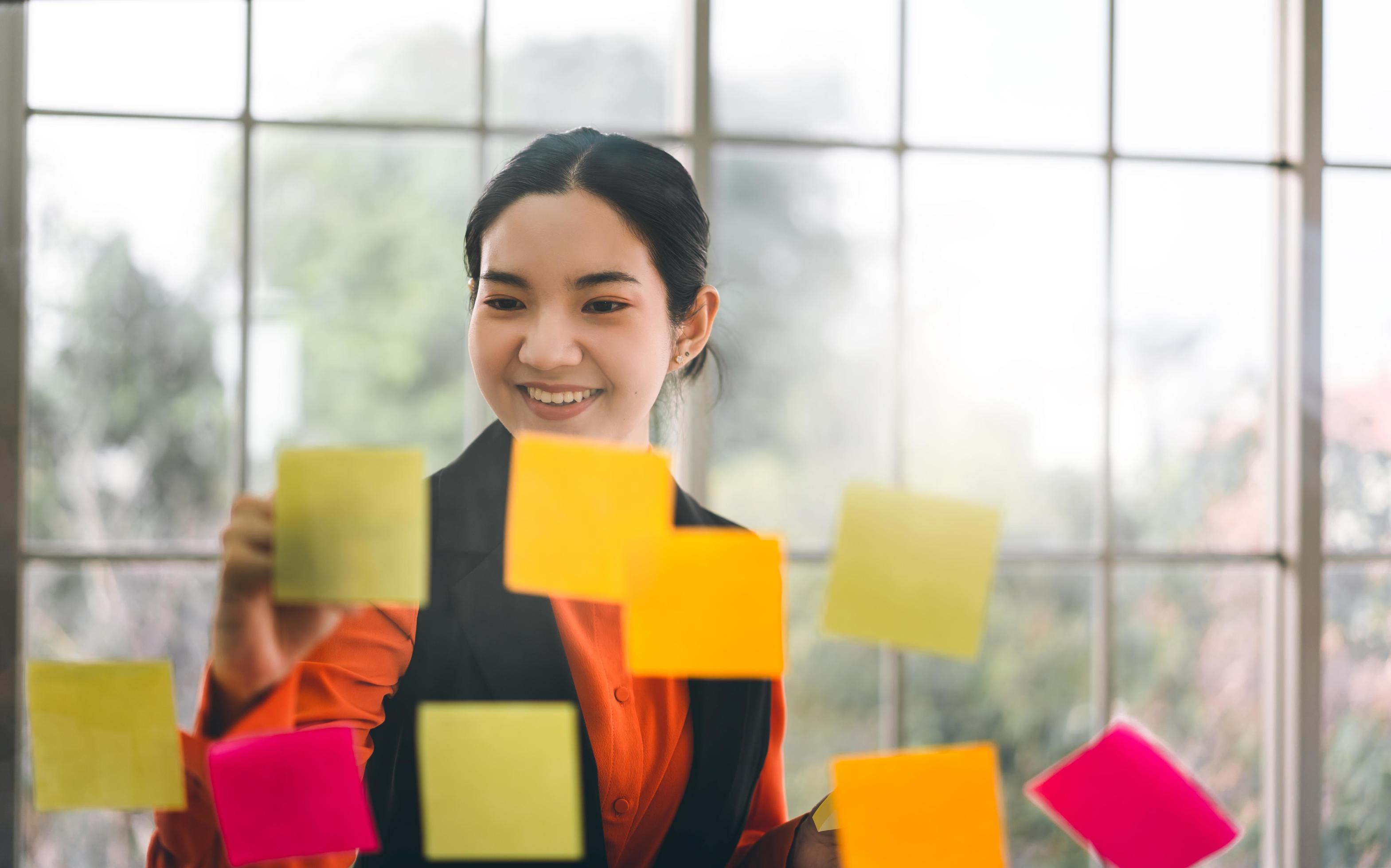 Business asian woman use message paper stick on glass board with window light. Stock Free