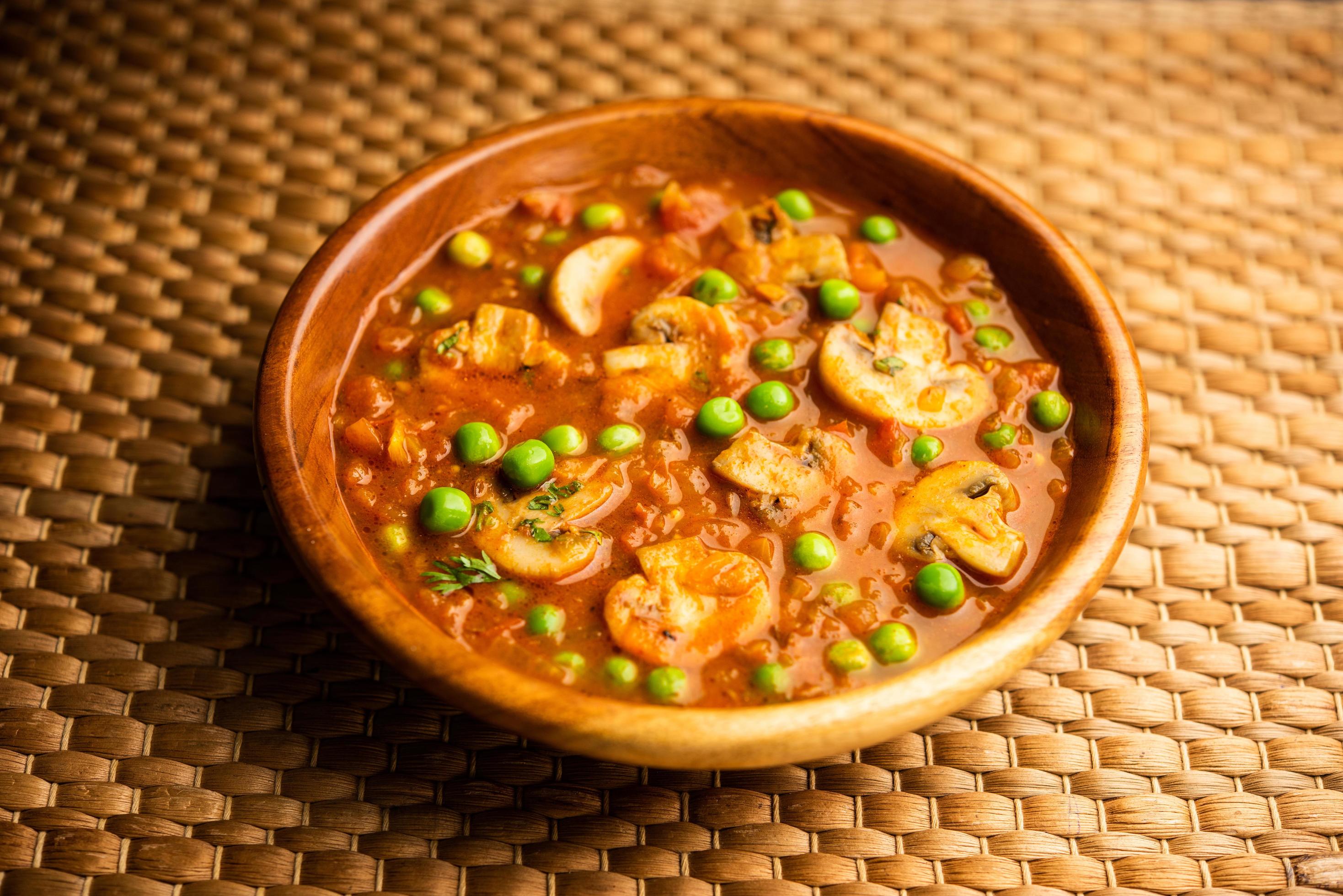 Mushroom and Pea Curry with Roasted Garlic, Indian food served in a bowl Stock Free