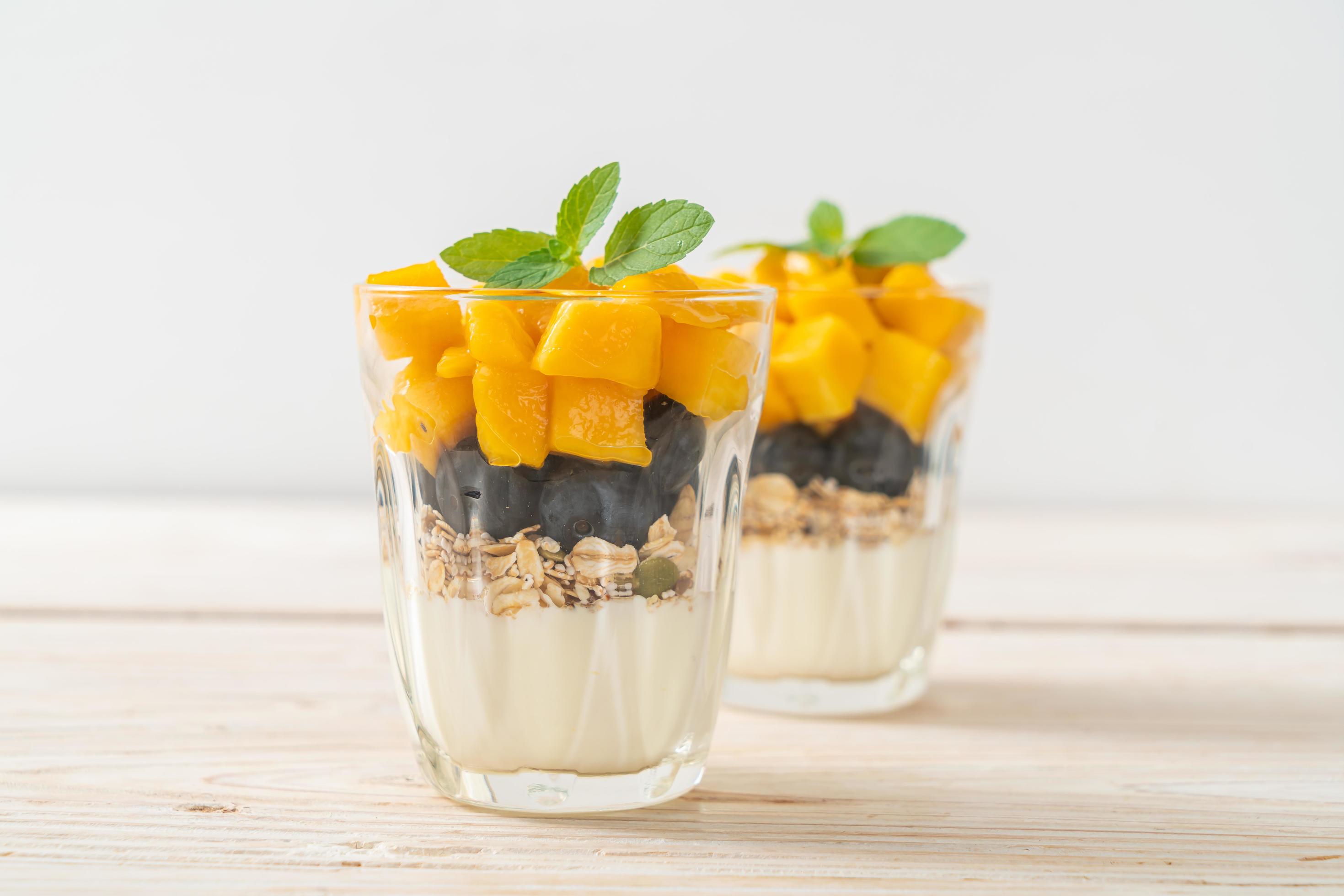 Homemade fresh mango and fresh blueberry with yogurt and granola – healthy food style Stock Free