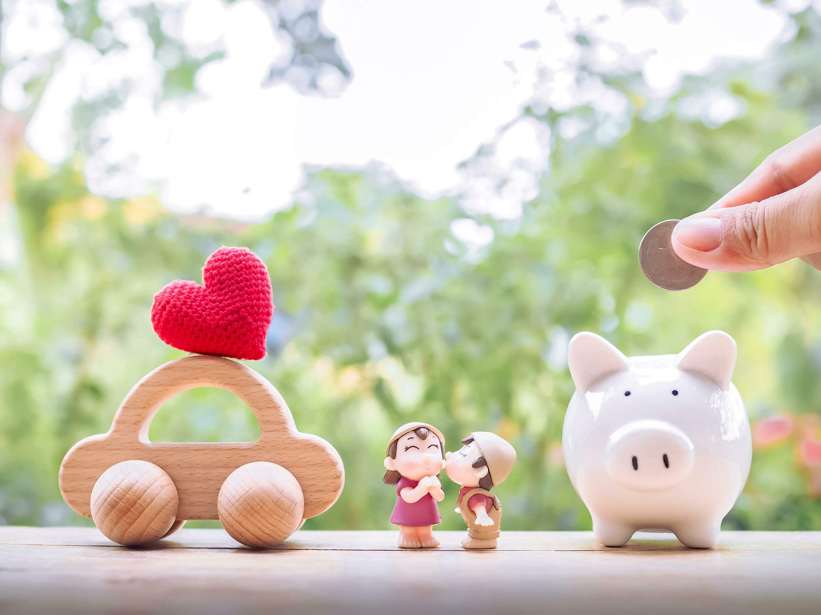 Piggy bank, wooden toy car and lovely couple. The concept of saving for car of family. Stock Free