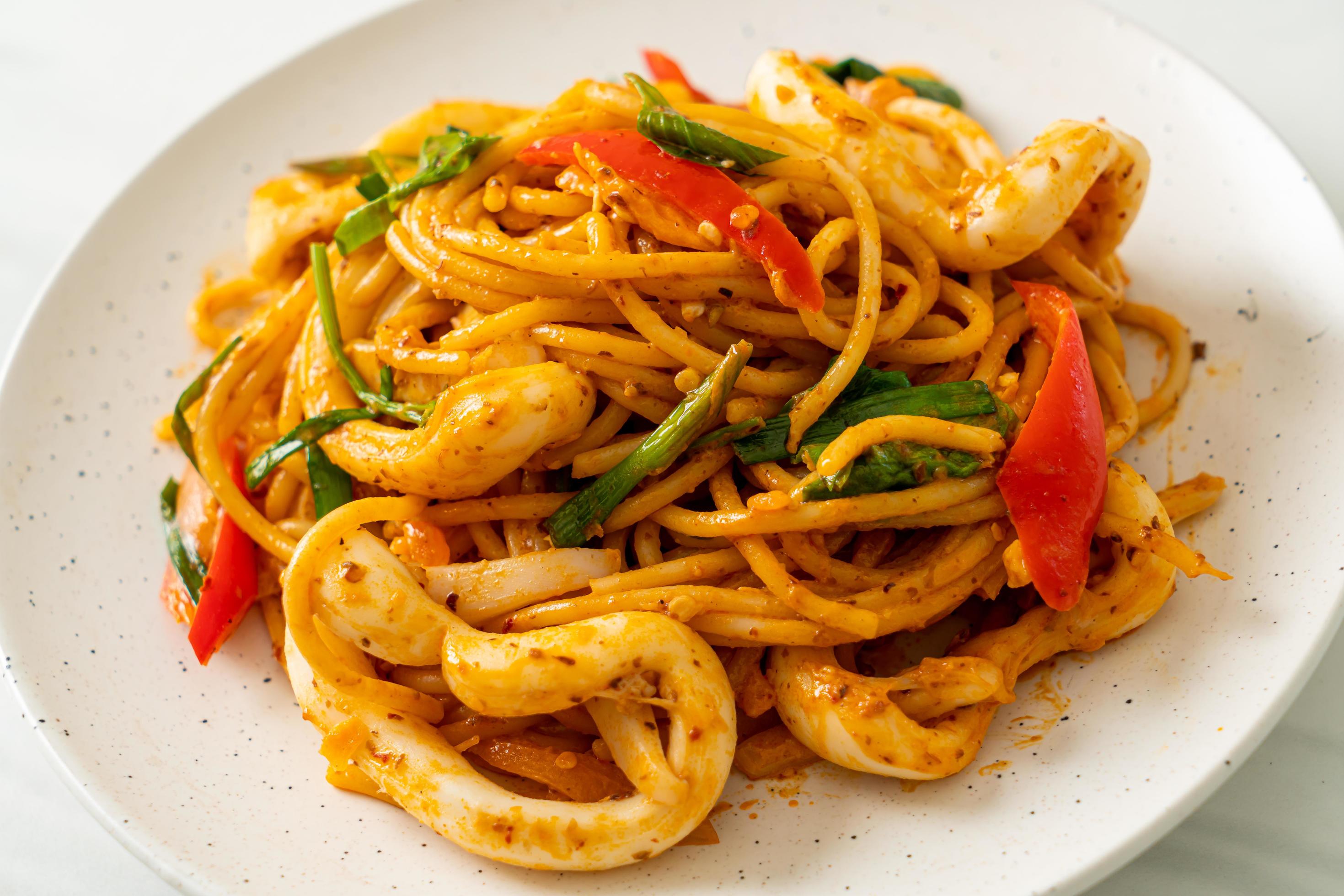 Stir-fried spaghetti with salted egg and squid – fusion food style Stock Free