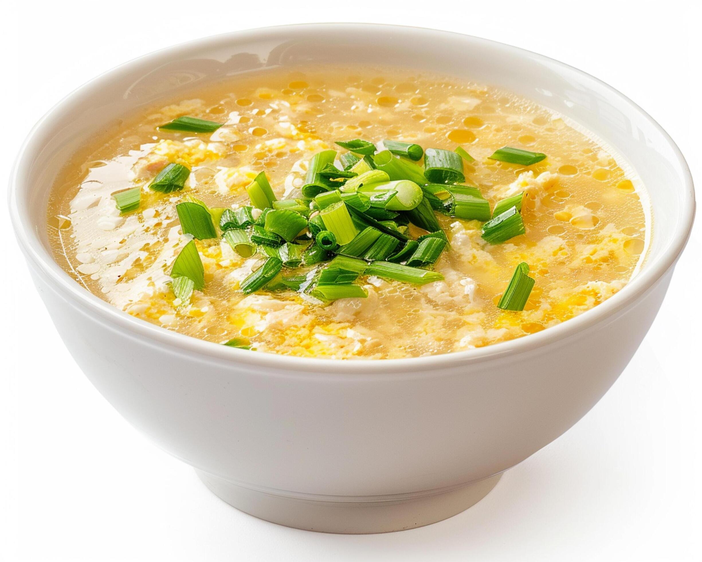 a bowl of soup with green onions in it Stock Free