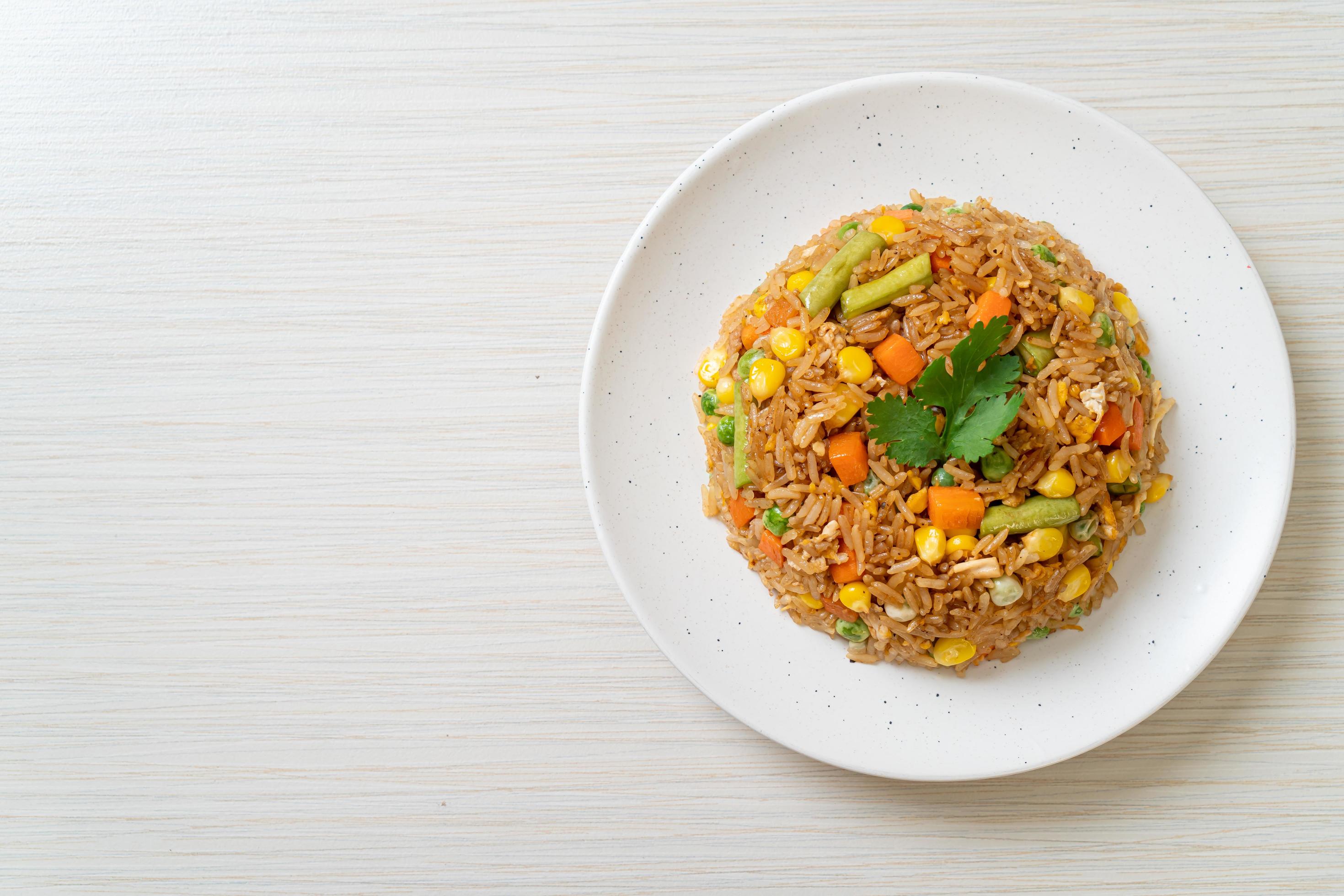 Fried rice with green peas, carrots, and corn – vegetarian and healthy food style Stock Free