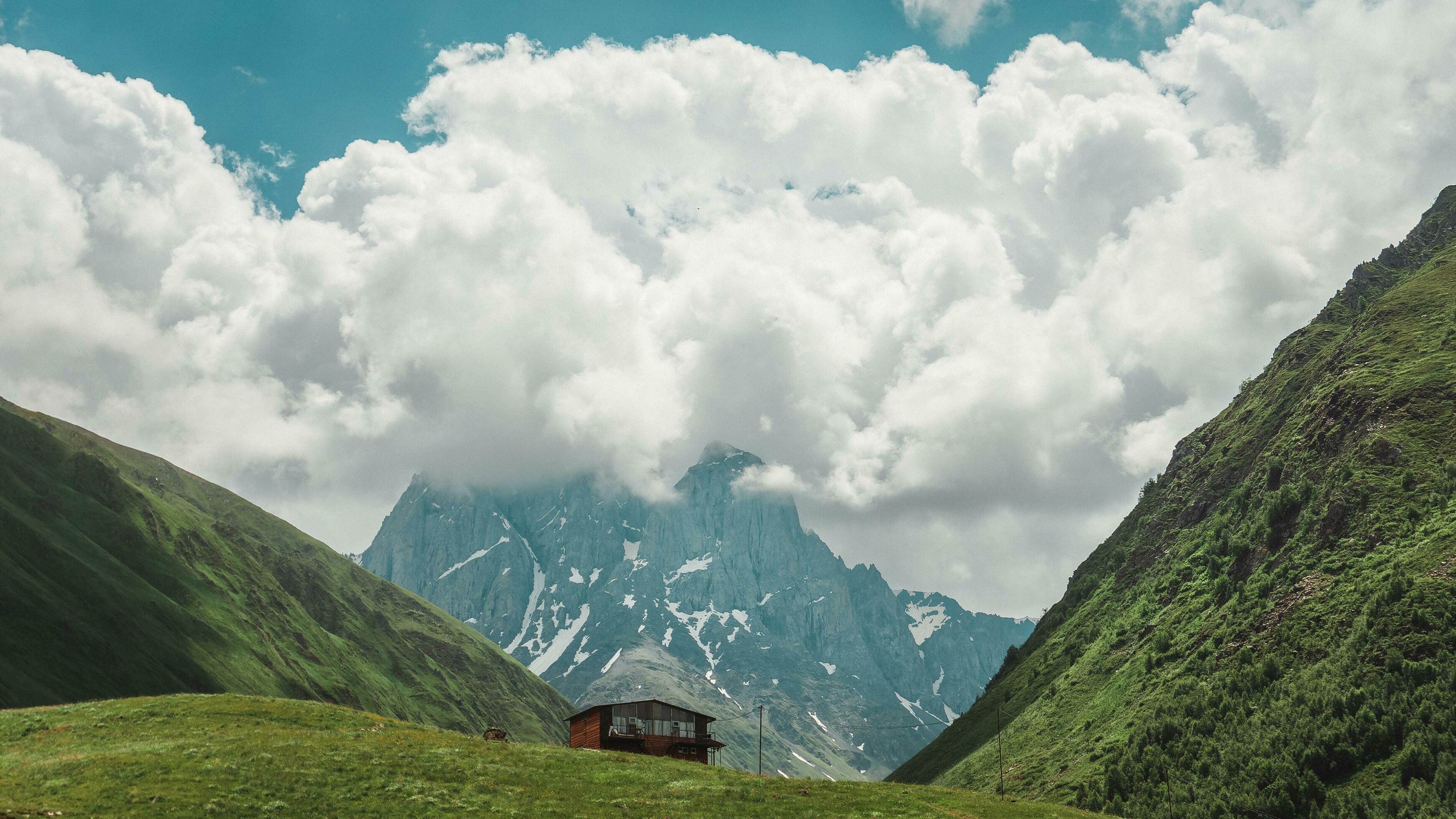 Picturesque rocks and mountains, a beautiful lonely house stands against the background of the mountains. Amazing landscape of nature and sky Stock Free