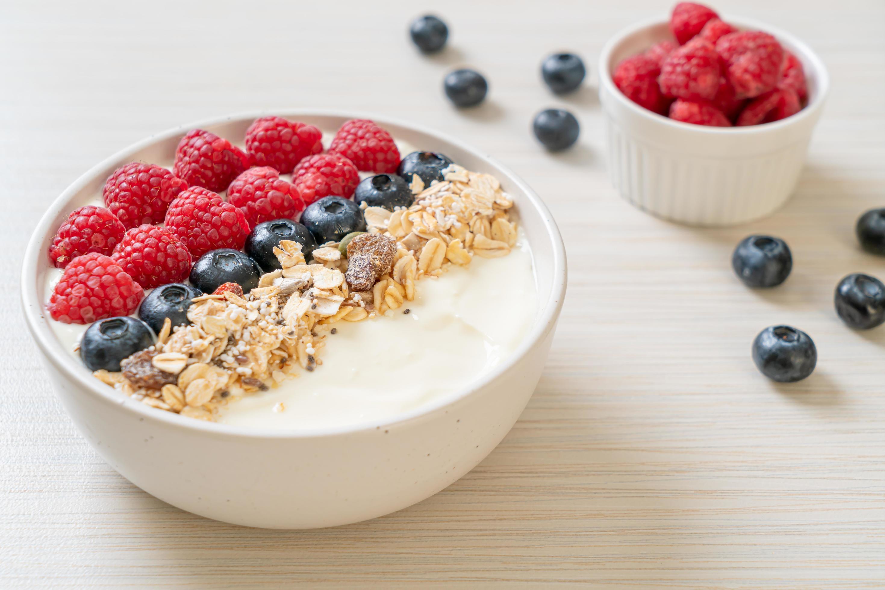 Homemade yogurt bowl with raspberry, blueberry and granola – healthy food style Stock Free