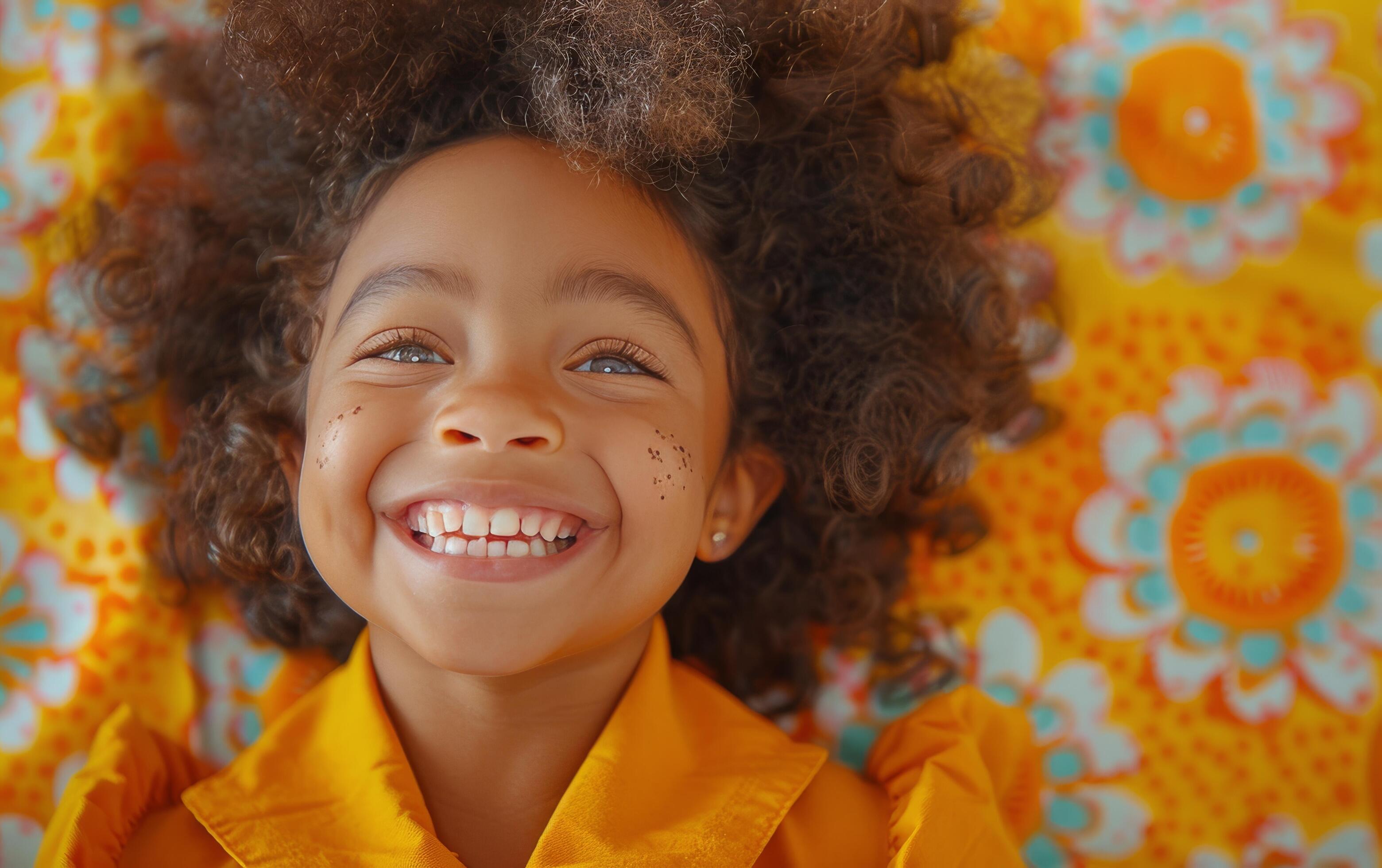 Young Girl With Curly Hair Smiles Against Colorful Floral Wall Stock Free