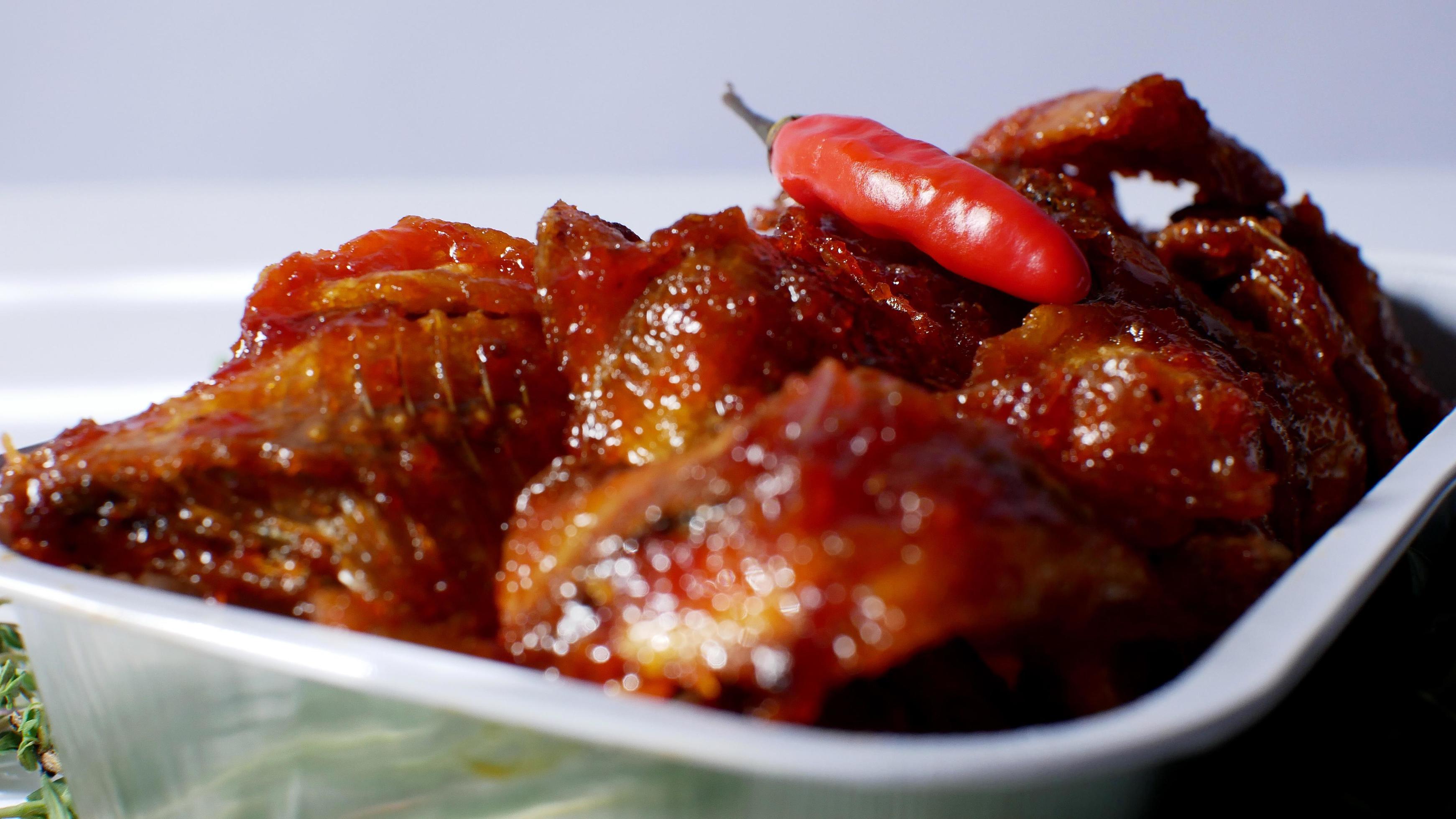 salted fish with spicy sweet and sour seasoning Indonesian food served simply in an aluminum place with white background Stock Free