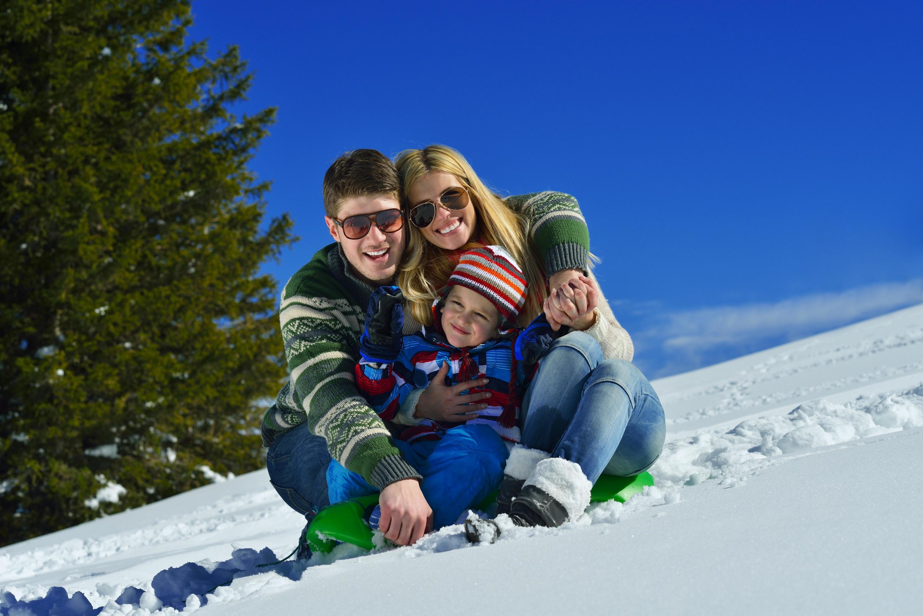 family having fun on fresh snow at winter vacation Stock Free