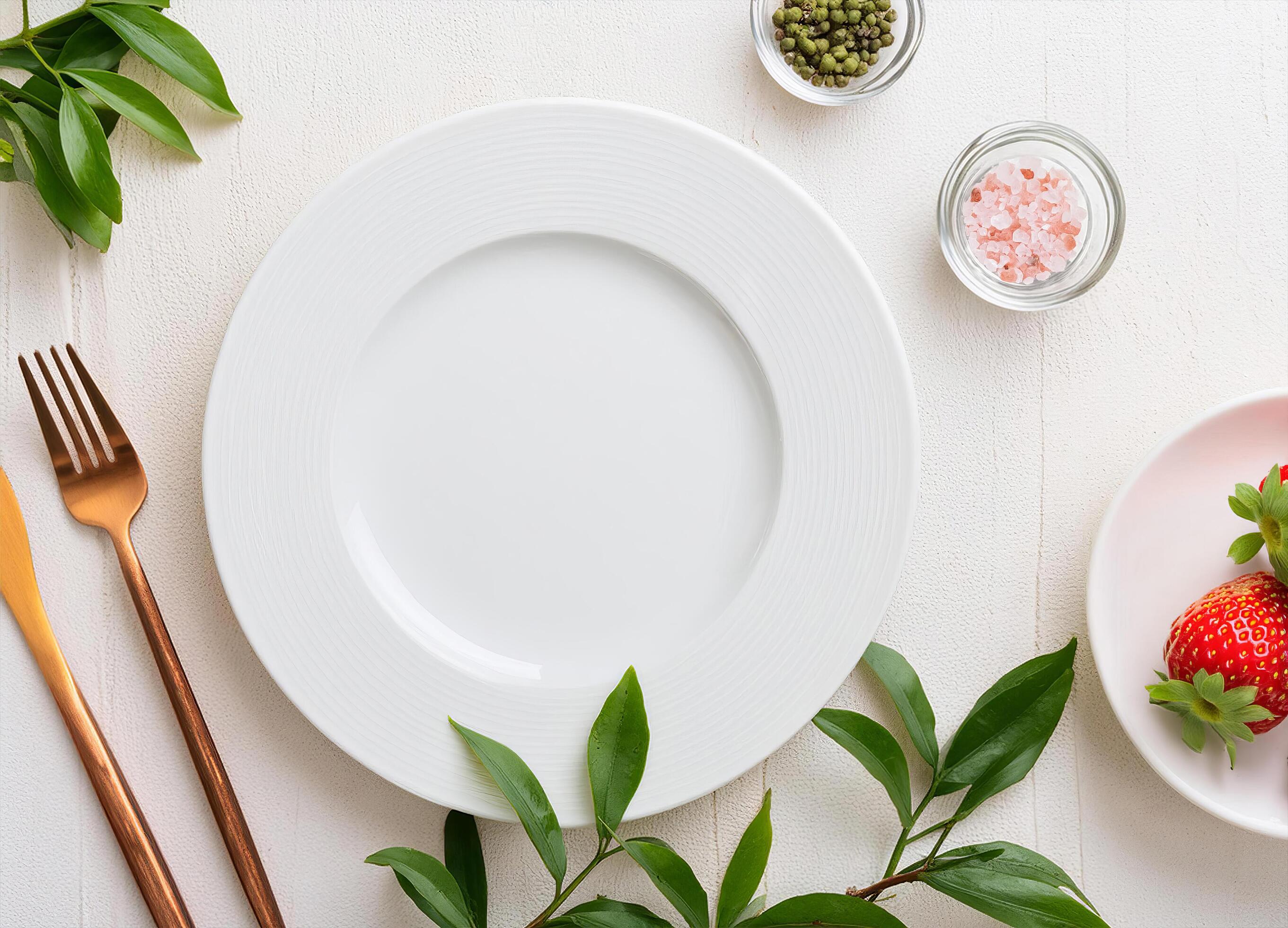 Top view of Empty white plate on white wood around with green leaves , fruit and pink salt Stock Free