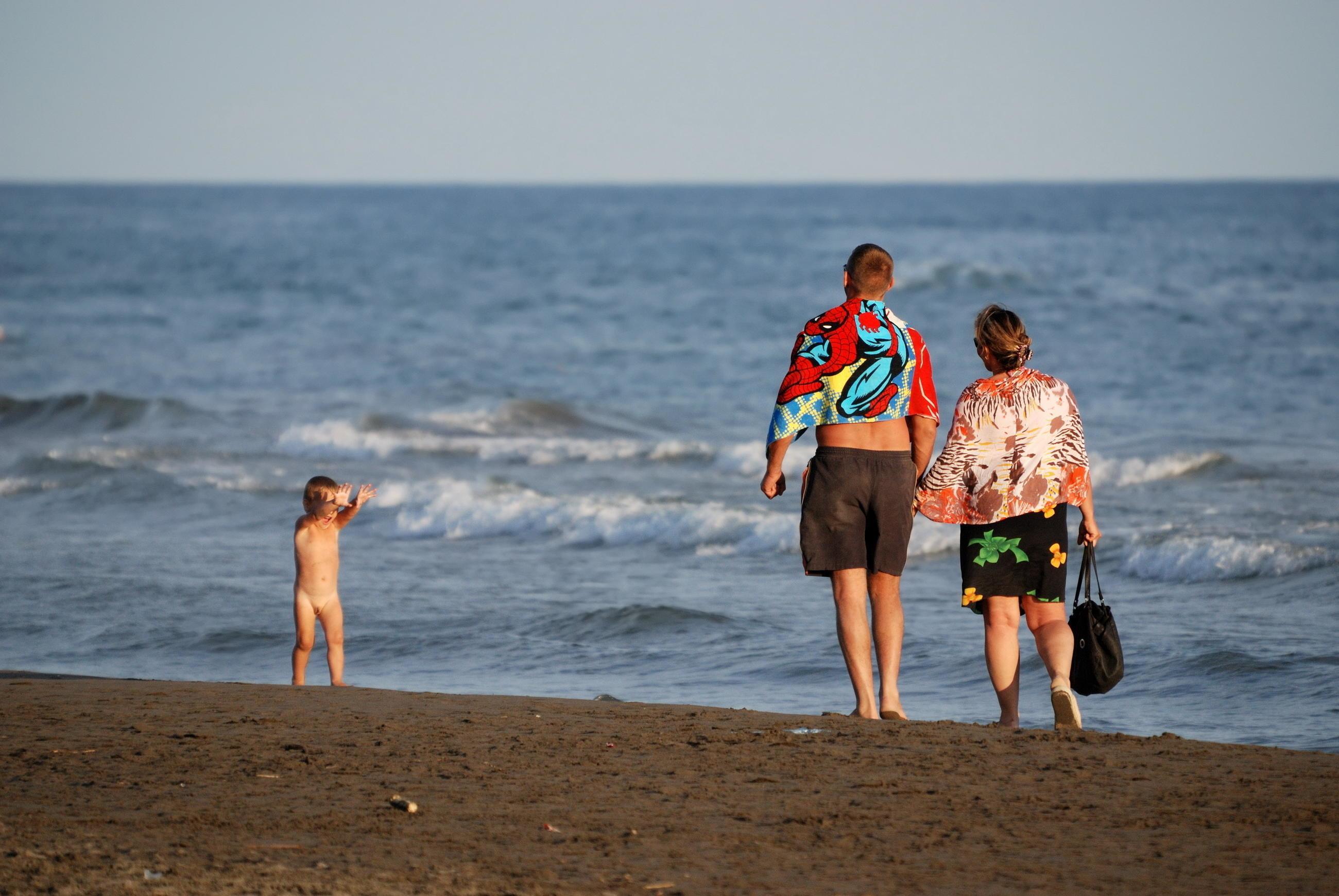 young family relaxing on beach Stock Free