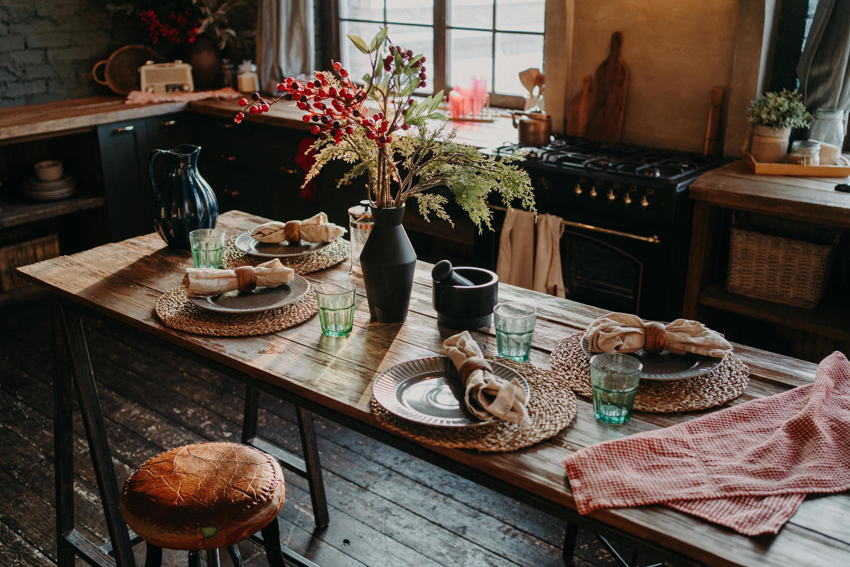 Table served for dinner. Cozy kitchen interior. Cultery and napkins on table for guests. Family breakfast. Dining time. No people. Stock Free