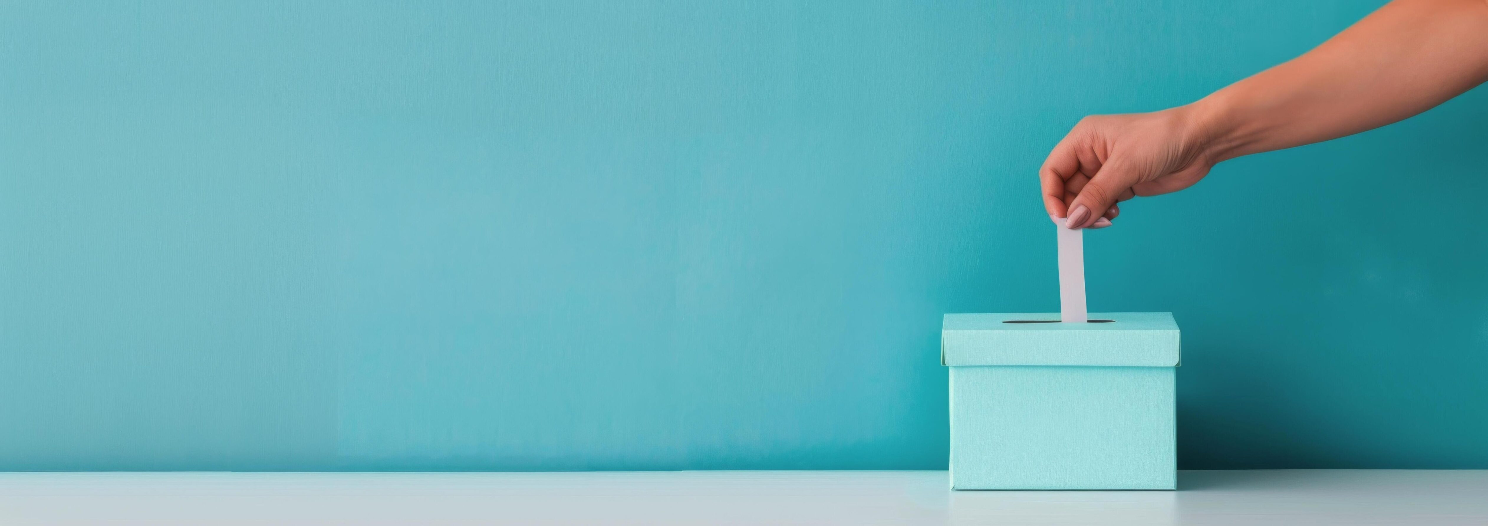 Hand Inserting Ballot Into Light Blue Box Against Teal Background Stock Free