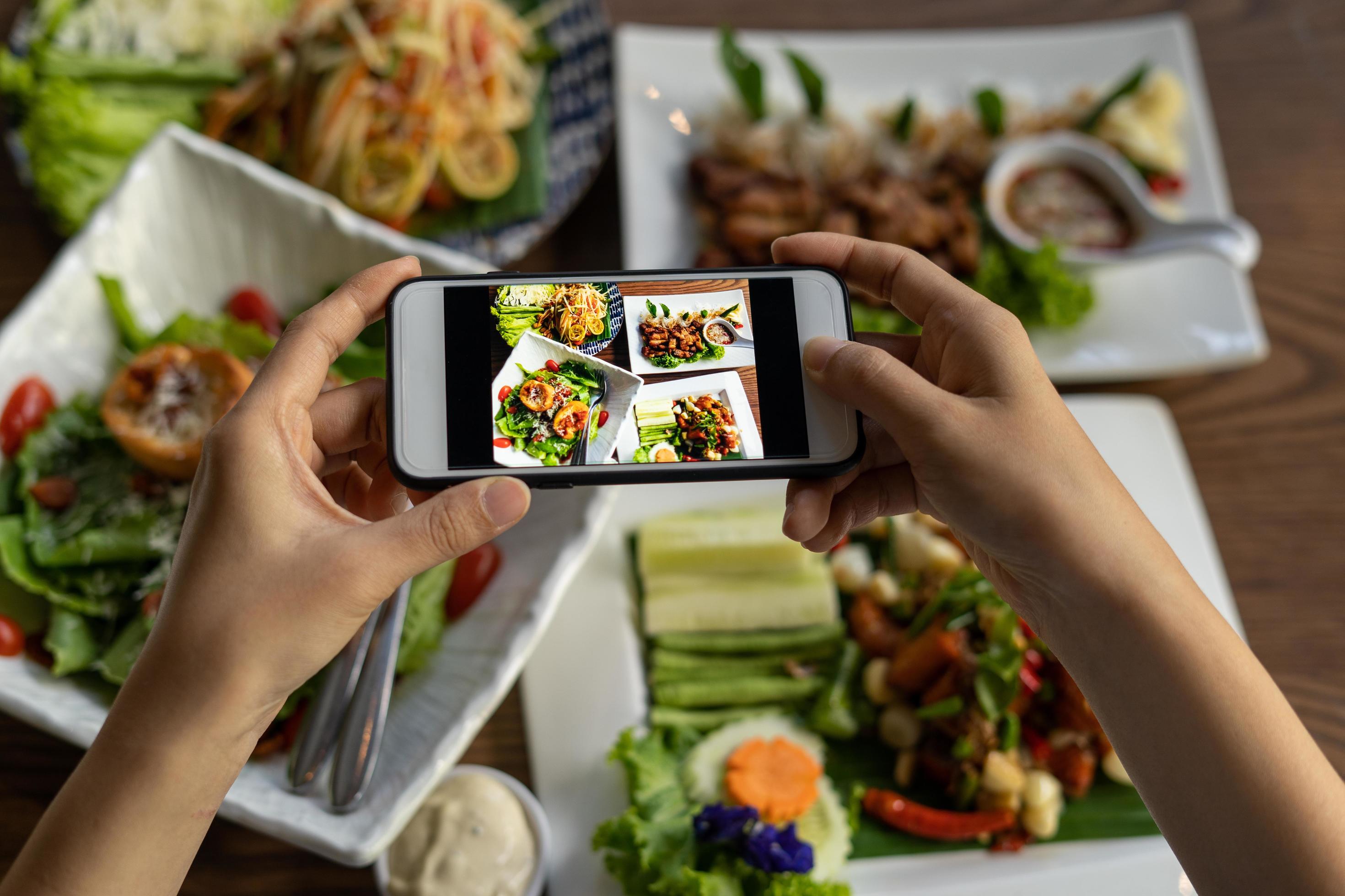 Woman take picture of a meal on the table after ordering food online to eat at home. Photography and use phone concepts Stock Free