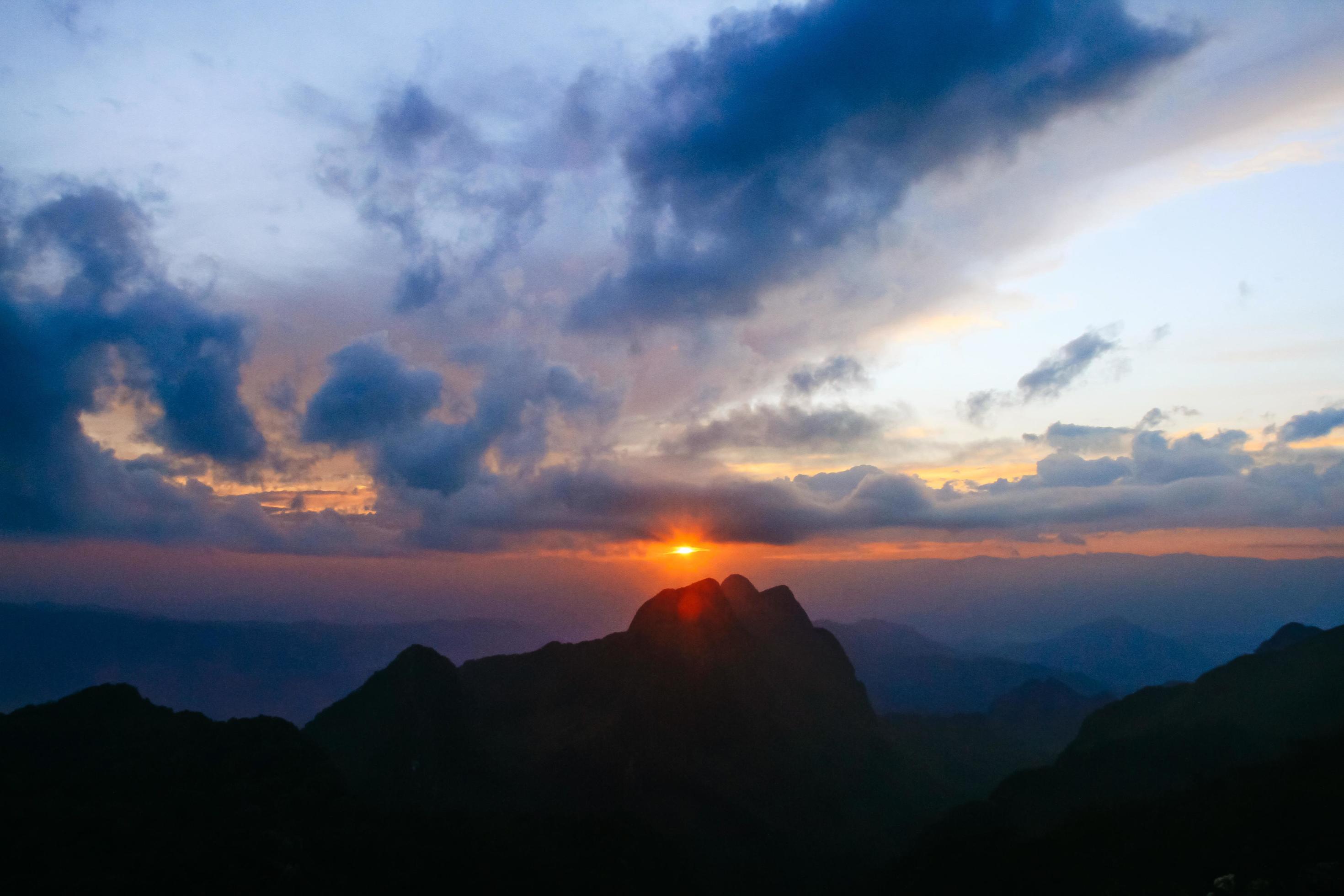 Sunset in sky and cloud, beautiful colorful twilight time with silhouette of mountain. Stock Free