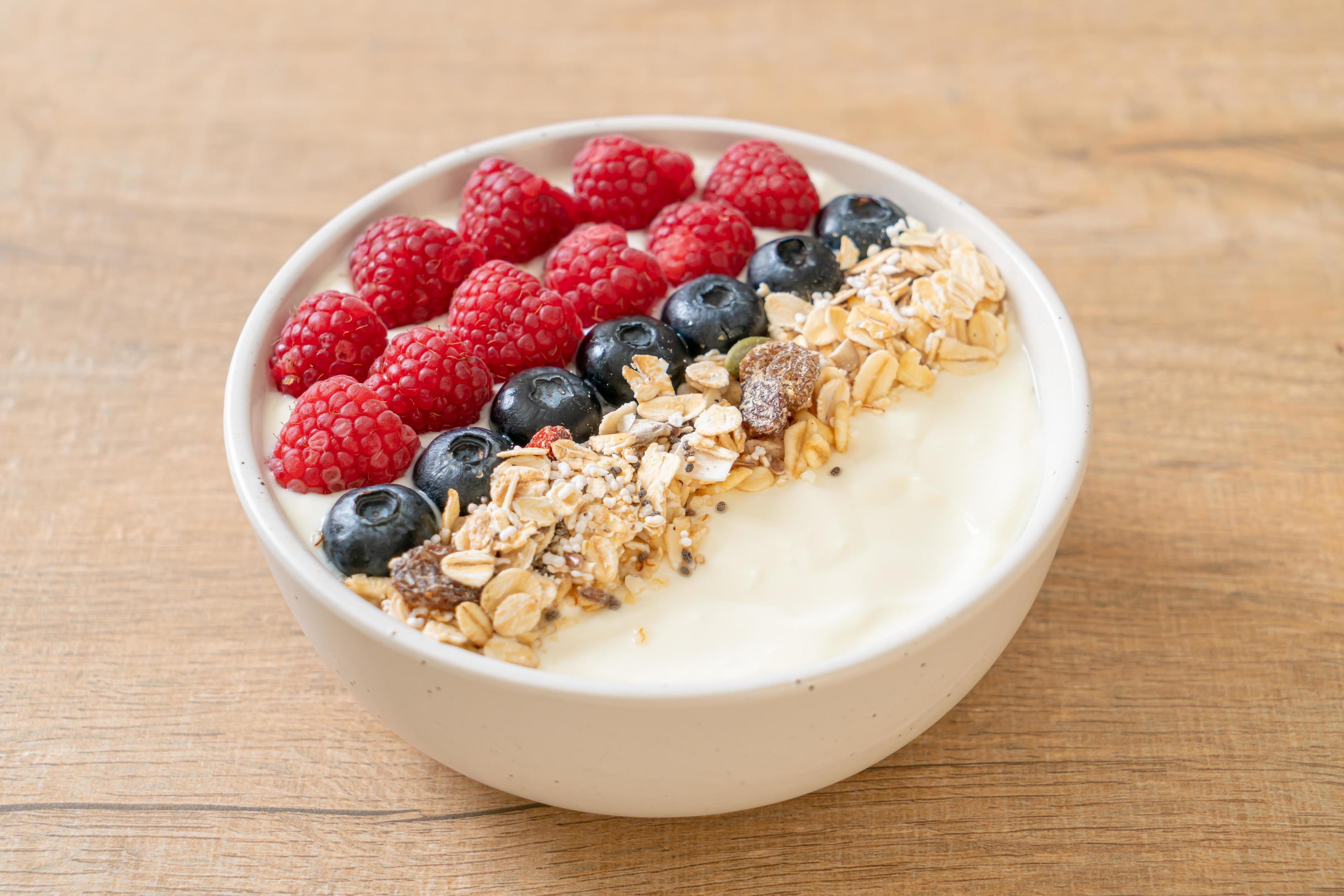 Homemade yogurt bowl with raspberry, blueberry and granola – healthy food style Stock Free