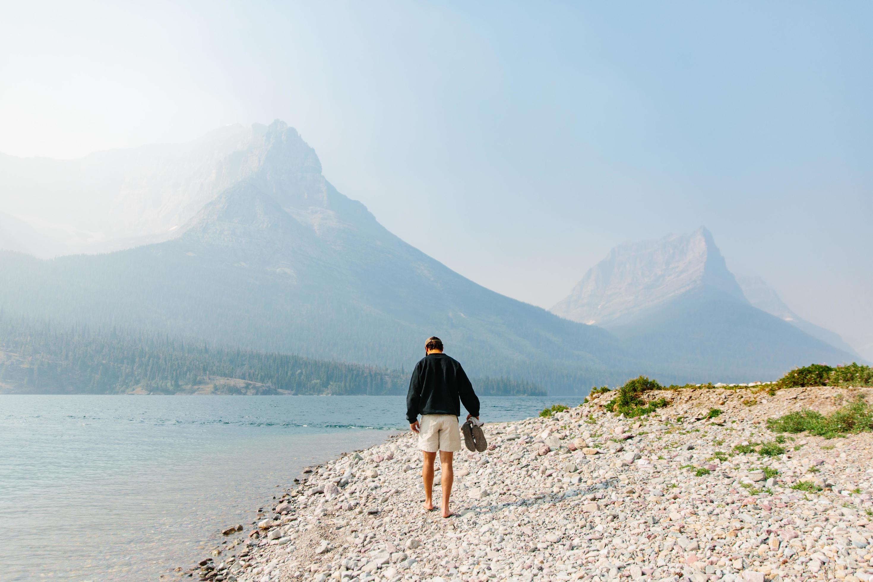 Man walking along shore in Montana Stock Free